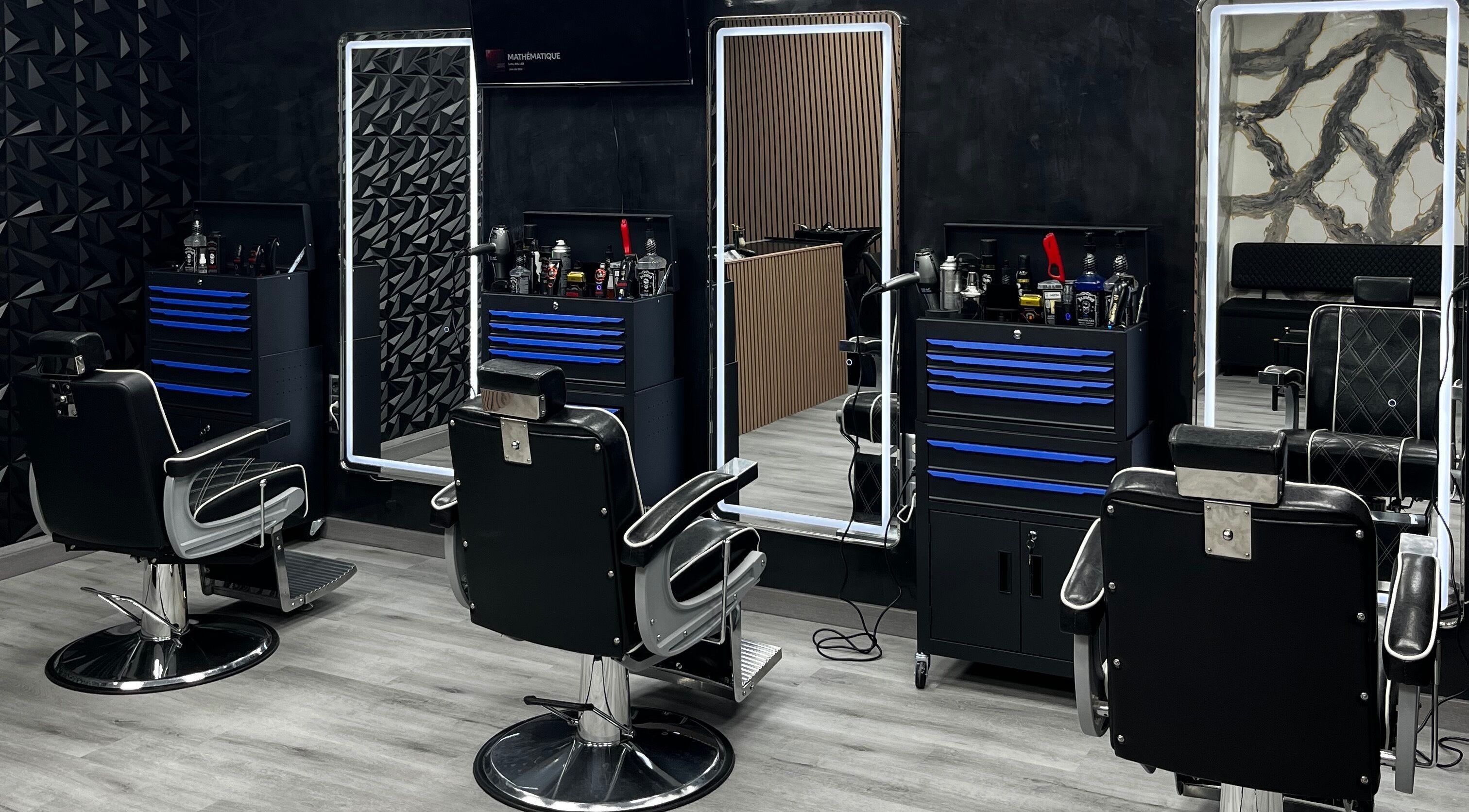 Interior moderno de Hassan's Barbershop 1 en Ripollet, Catalunya, ES, con sillas y espejos elegantes.