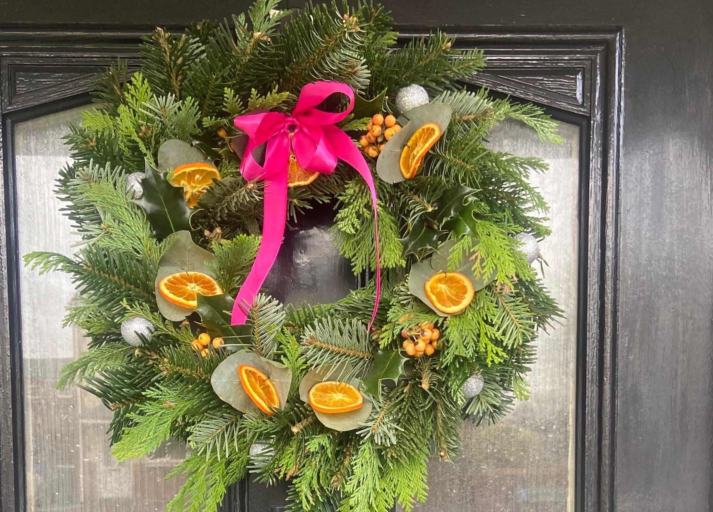 Festive wreath with pink ribbon on a door at Brow Babe, Stoke-on-Trent, England, GB.