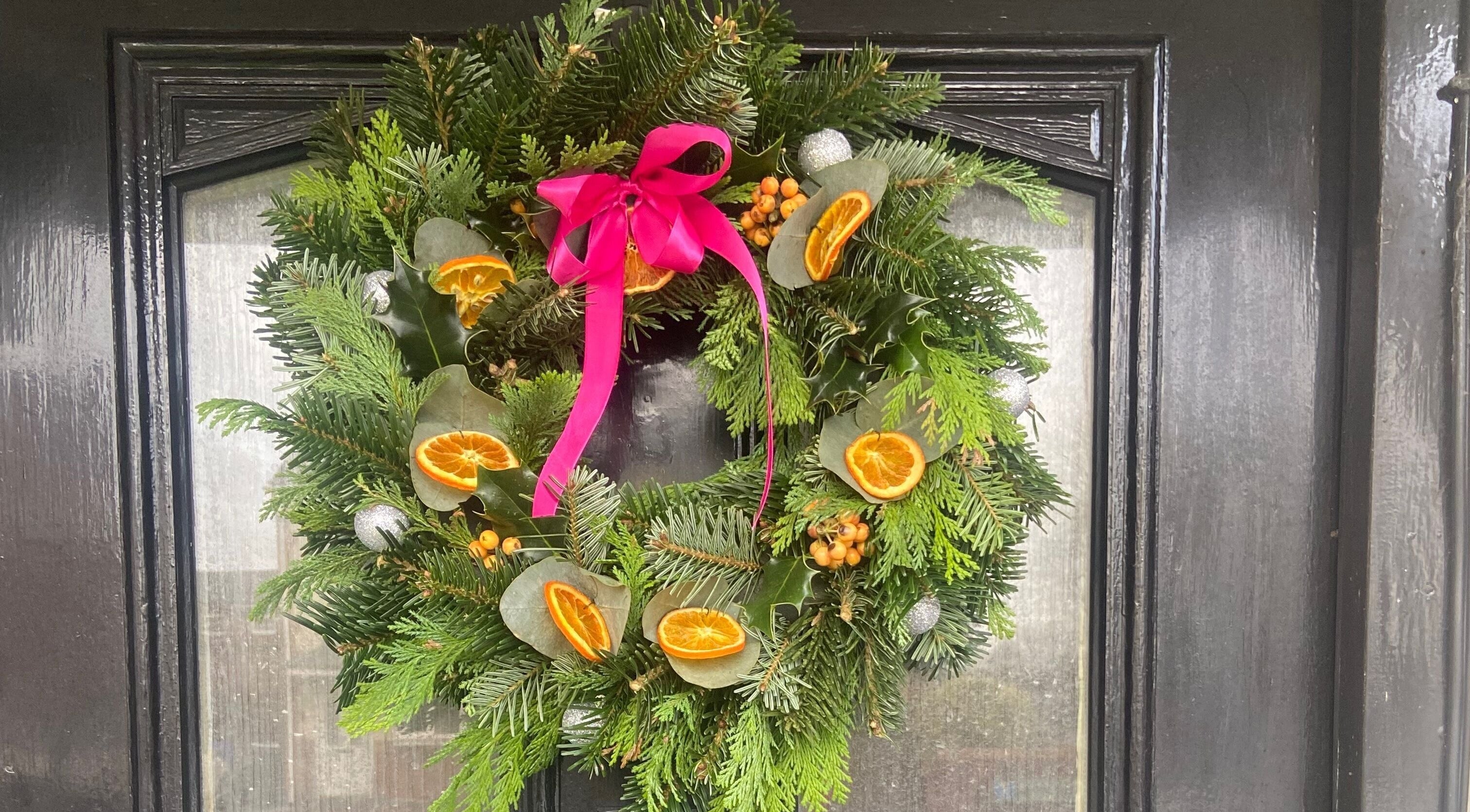Festive wreath with pink ribbon on a door at Brow Babe, Stoke-on-Trent, England, GB.