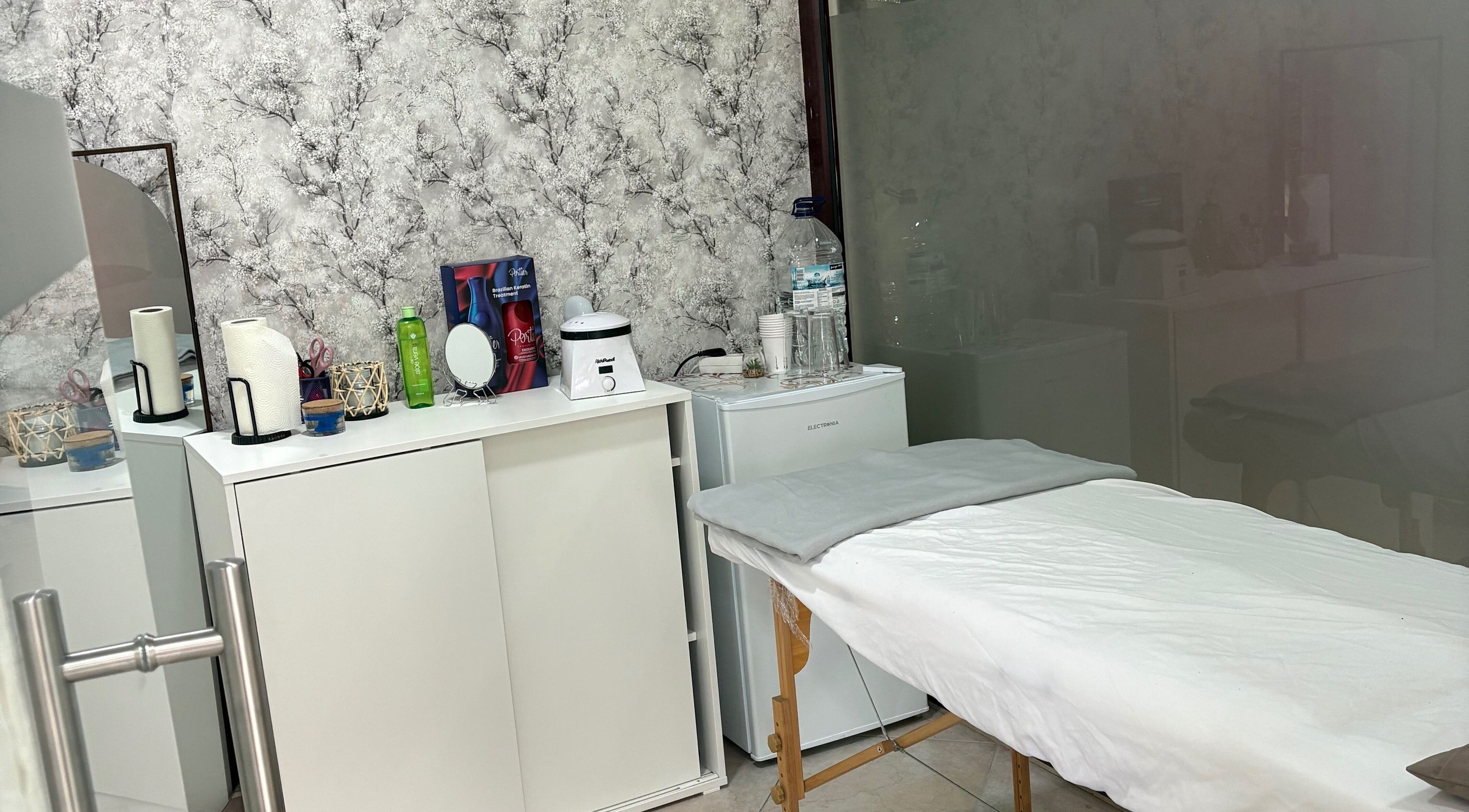 Sala de tratamento tranquila em Denise Dulino, Setúbal, Setúbal, PT, com mesa e decoração acolhedora.