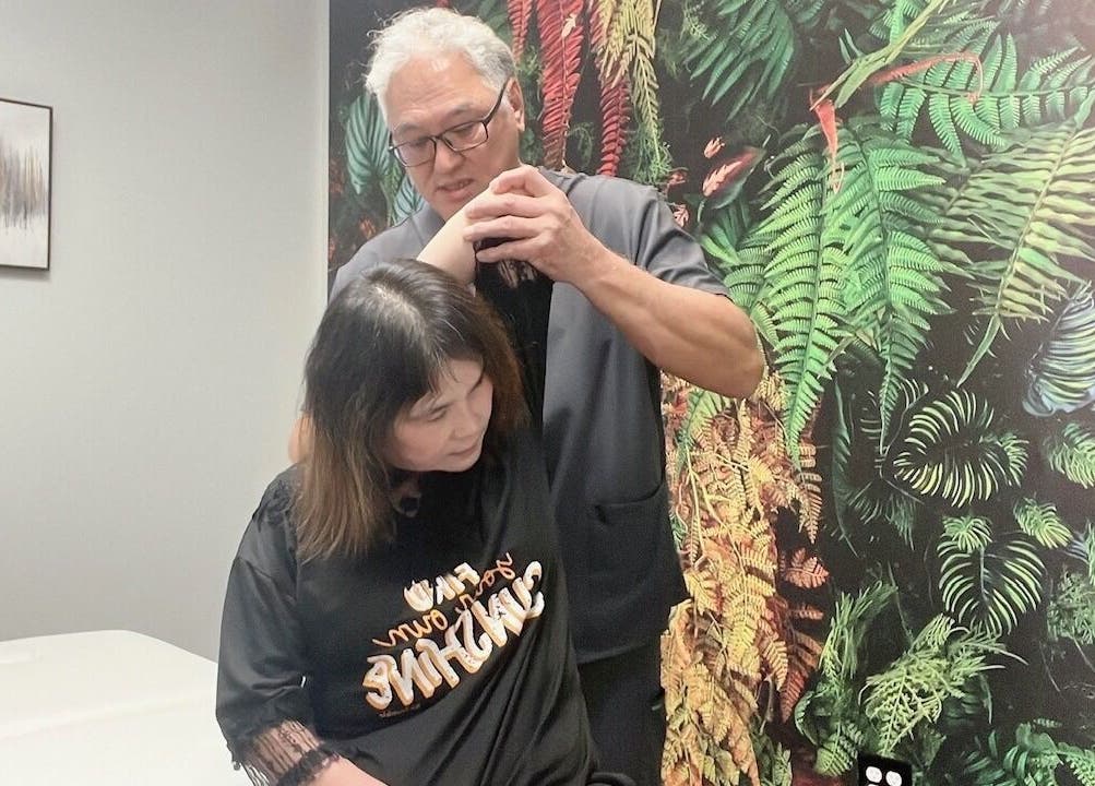 Client receiving arm therapy in a lush setting at THE REVIVE BAR, Allen, Texas, US.