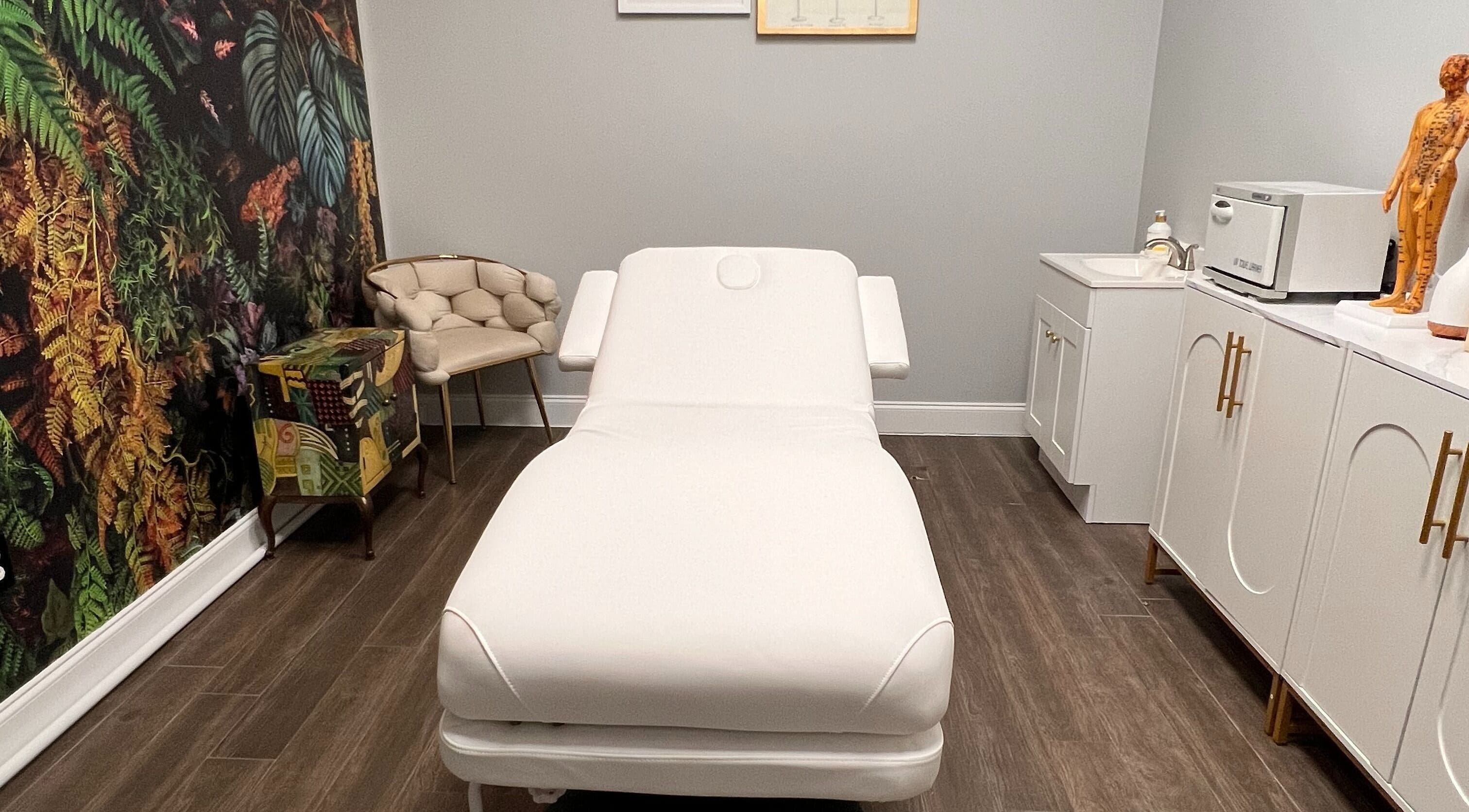 Relaxing treatment room at THE REVIVE BAR in Allen, Texas, US with a white spa bed and nature-inspired decor.