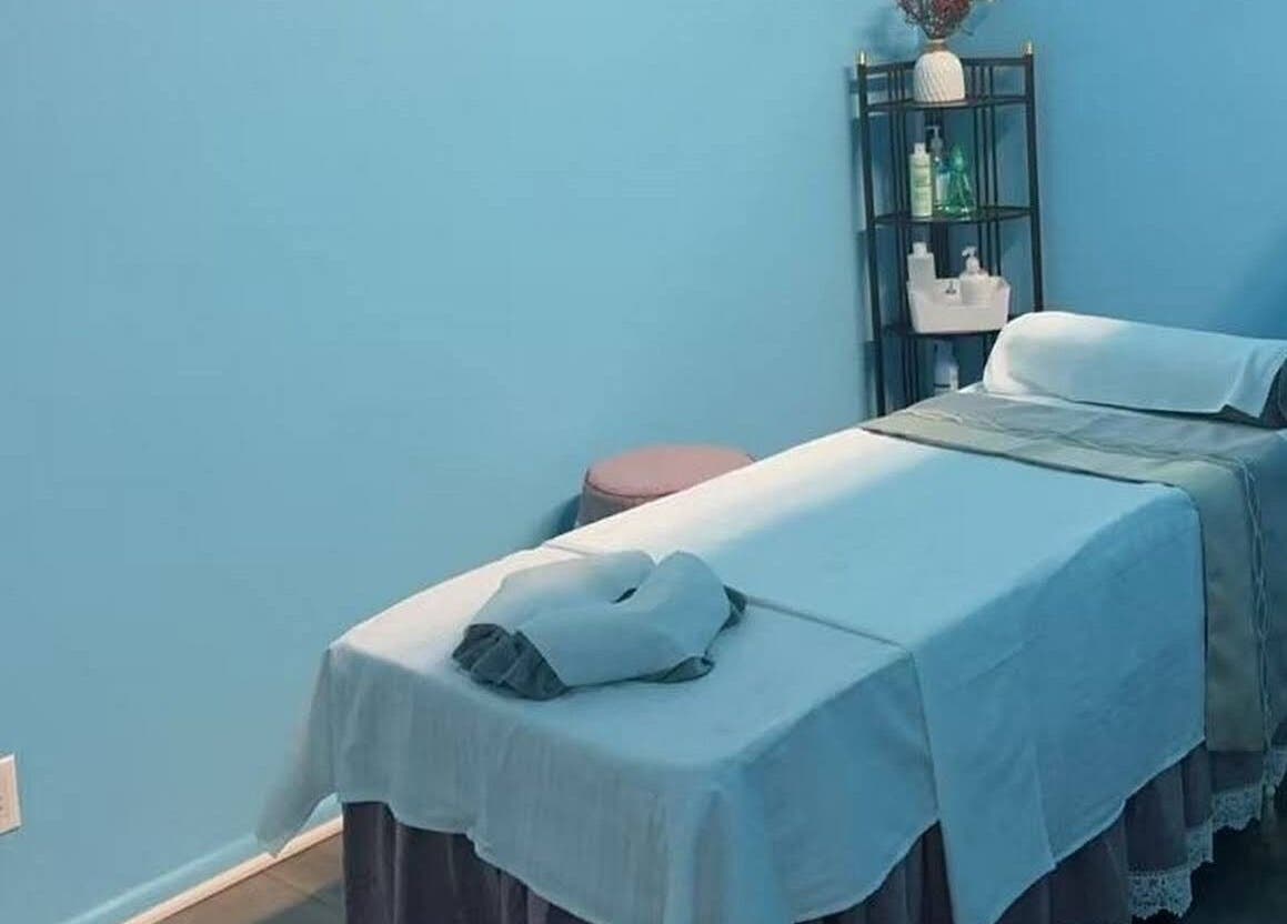 Relaxing massage room at XINGXING MASSAGE in Pomona, California, US with tranquil blue tones and spa equipment.