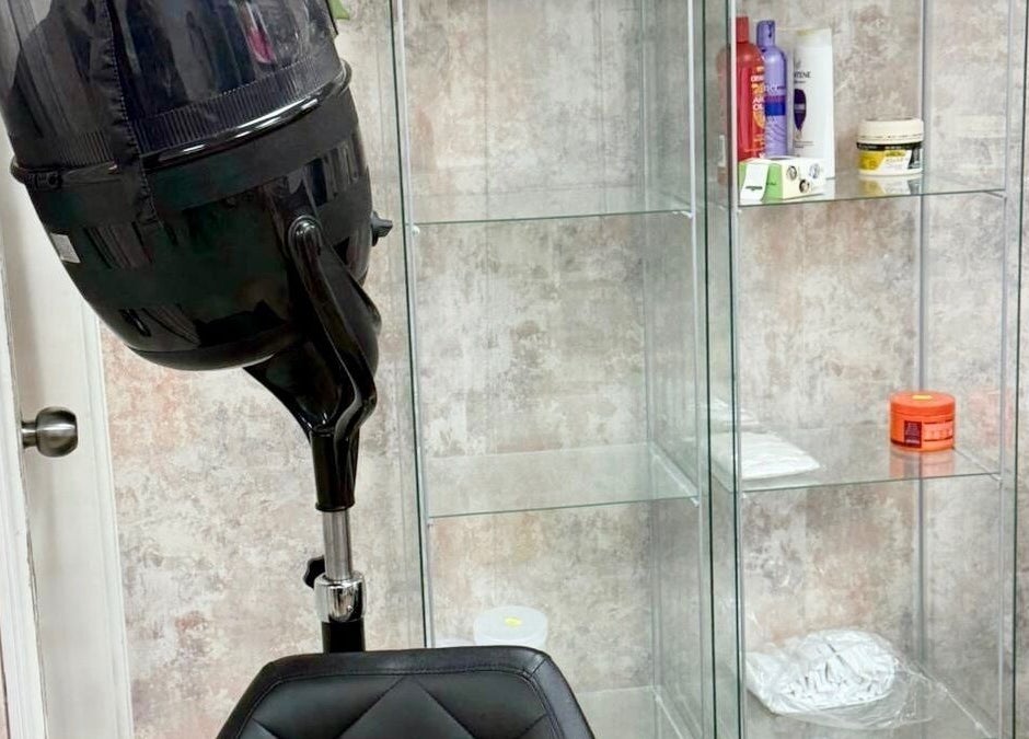 Comfortable salon chair and hairdryer at Dreads by Dy, London, England, GB, showcasing sleek modern design.