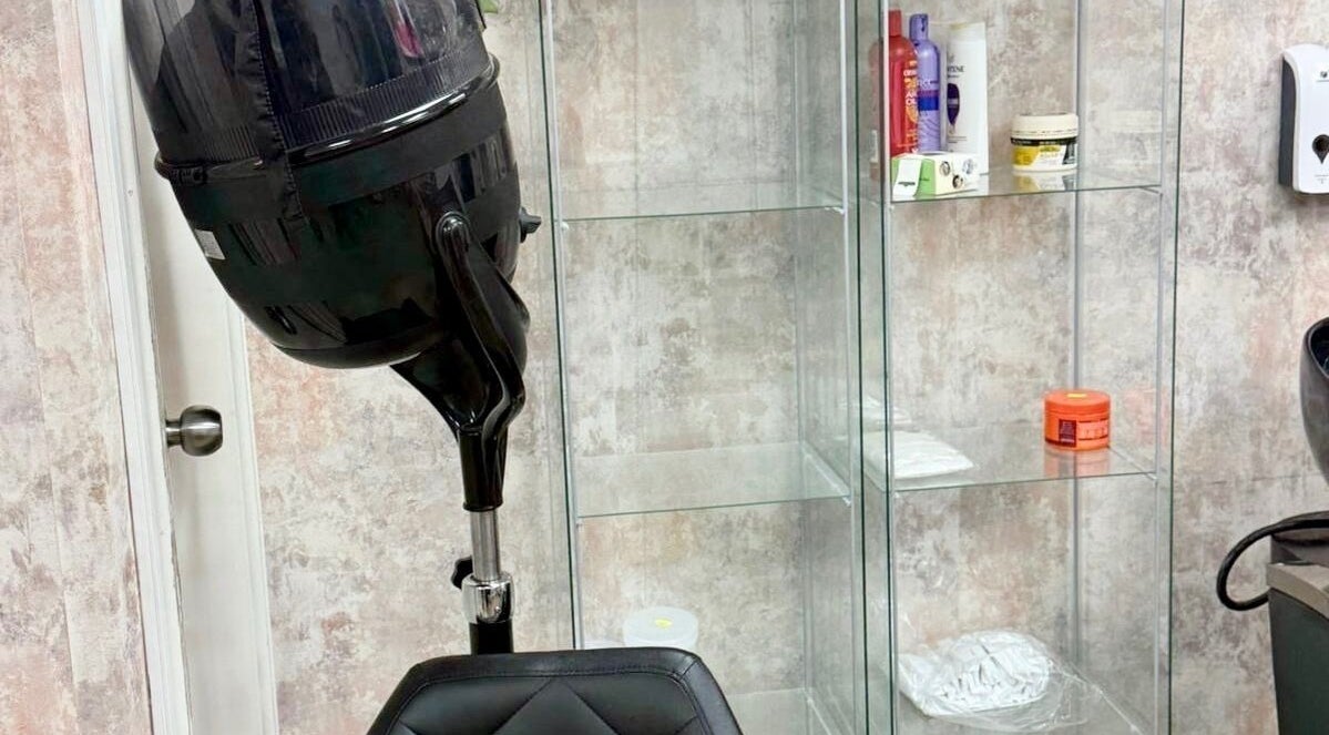 Comfortable salon chair and hairdryer at Dreads by Dy, London, England, GB, showcasing sleek modern design.