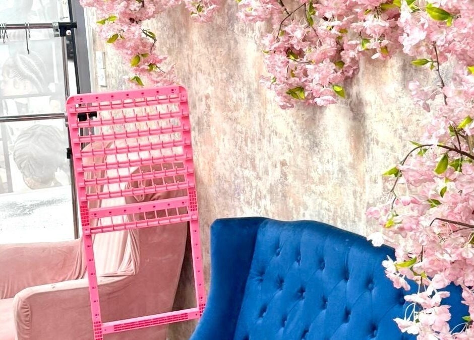 Chic lounge area at Dreads by Dy, London, England, GB with pink cherry blossoms and blue seating.