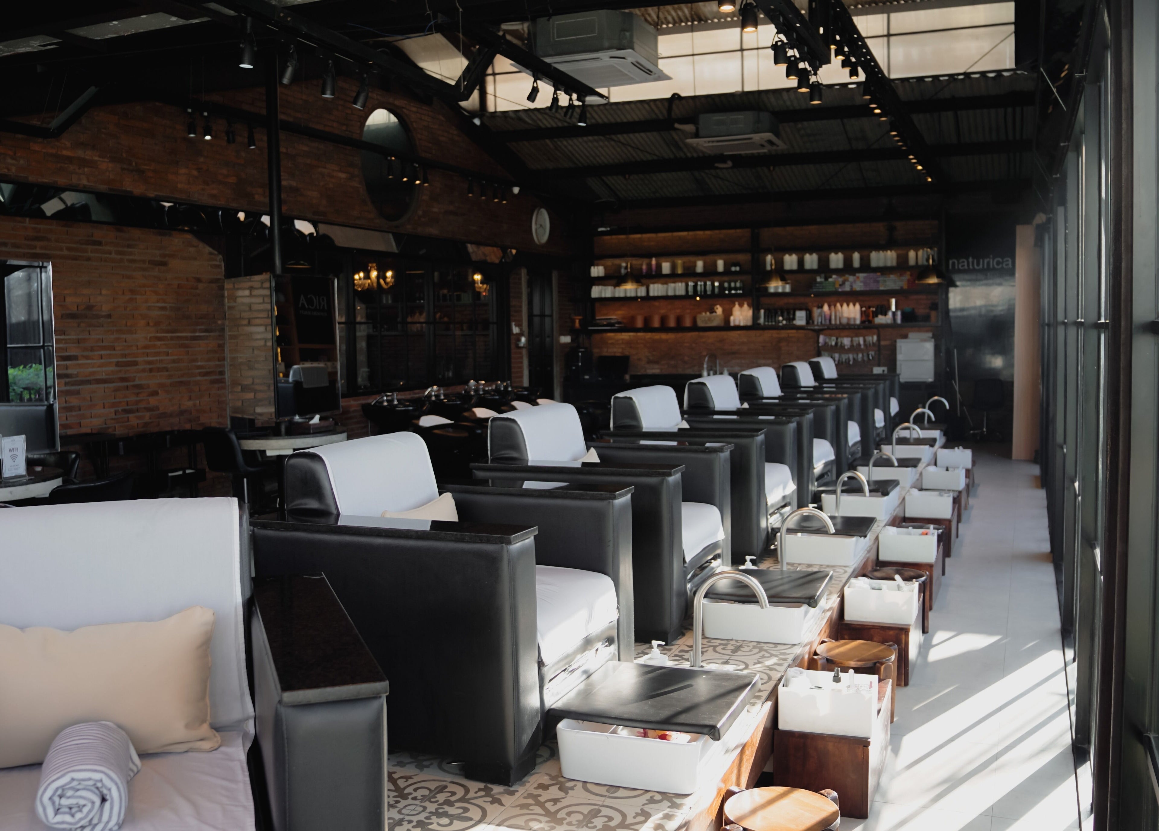 Chic pedicure chairs line the sunlit interior of Amo Spa in Bali, Bali, ID.