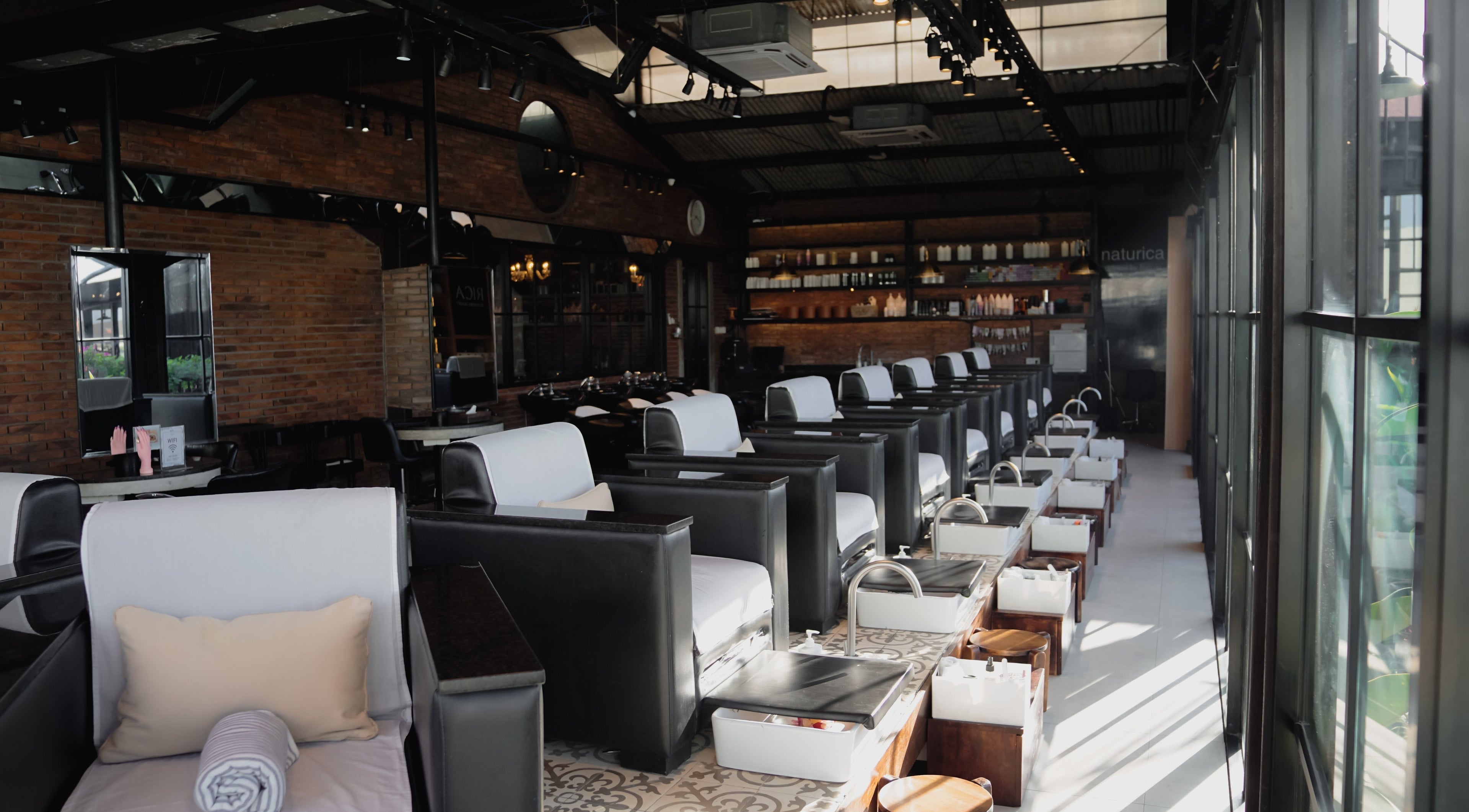 Chic pedicure chairs line the sunlit interior of Amo Spa in Bali, Bali, ID.