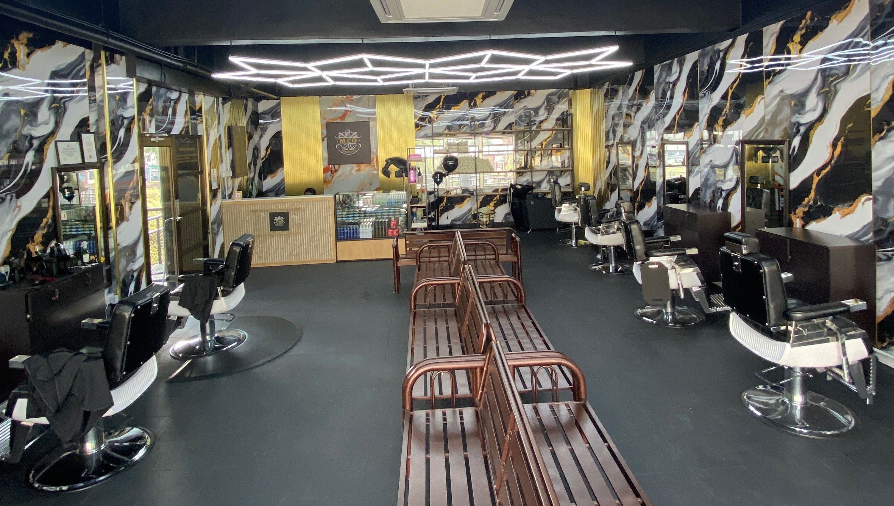 Modern interior of MCo Barbershop Hq in Shah Alam, Selangor with chic decor and elegant barber chairs.