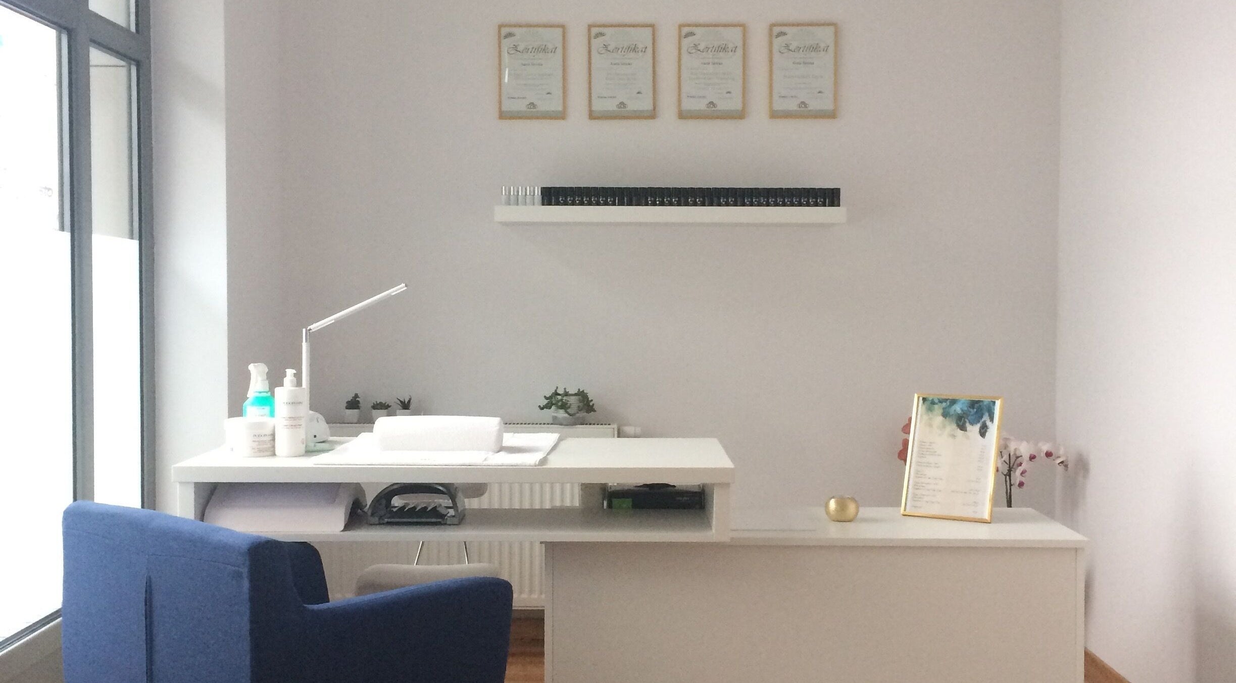 Eleganckie wnętrze Beauty Design by Janicka, Wrocław, Województwo Dolnośląskie, PL. Minimalistyczne biurko i certyfikaty.