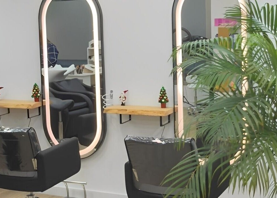 Interior de Tais Uñas en L'Escala, Catalunya, ES, con sillas de peluquería y espejos iluminados.