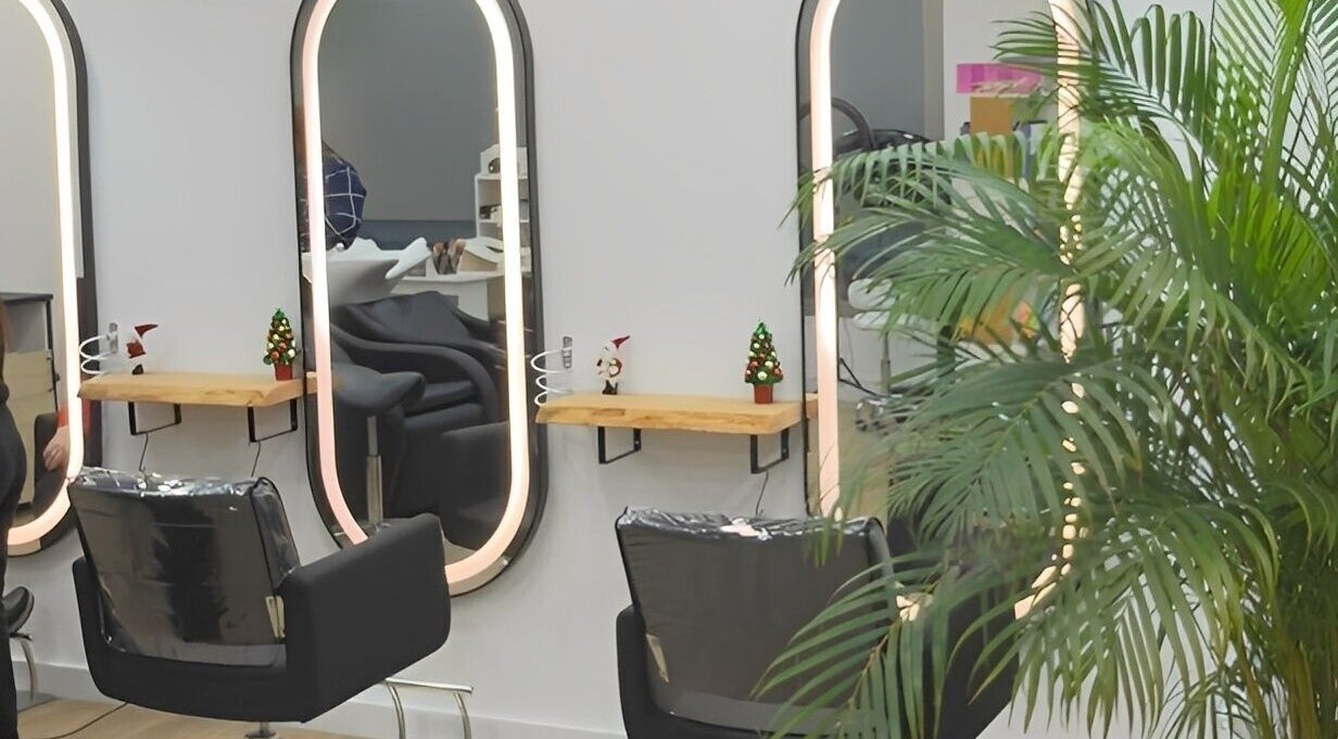 Interior de Tais Uñas en L'Escala, Catalunya, ES, con sillas de peluquería y espejos iluminados.