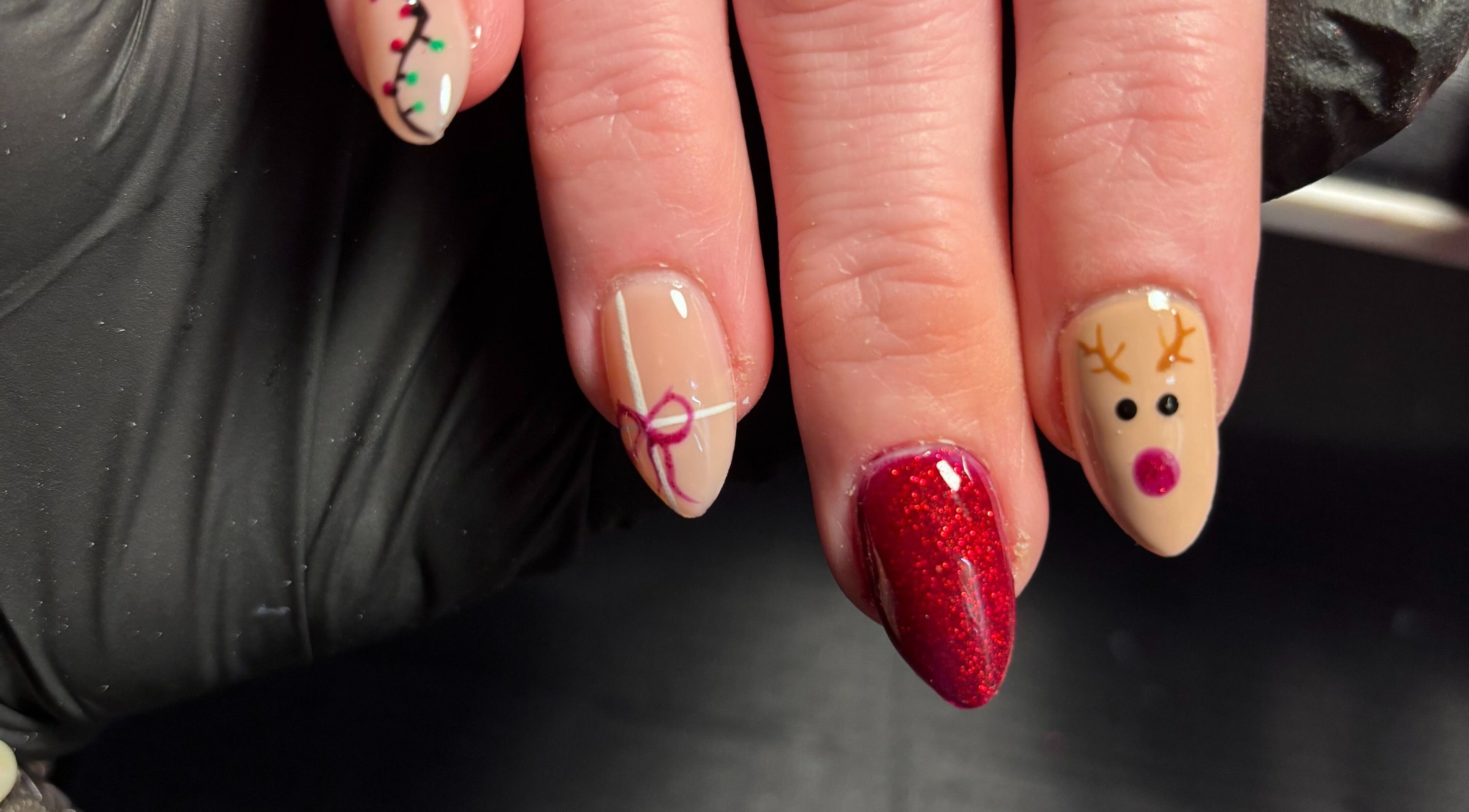 Holiday-themed nail art at Black Cat Nails in Long Lawford, England, GB features reindeer and gift designs.