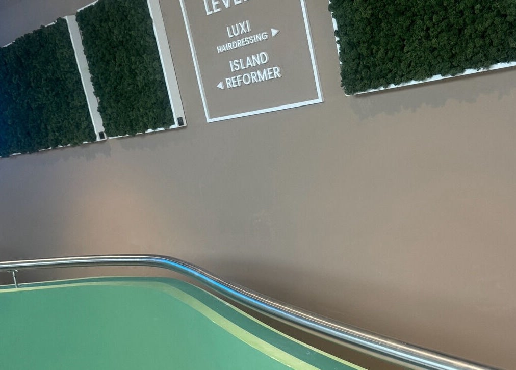 Entrance to Luxi Hairdressing in Tas-sliema, MT with green decor and clear signage.