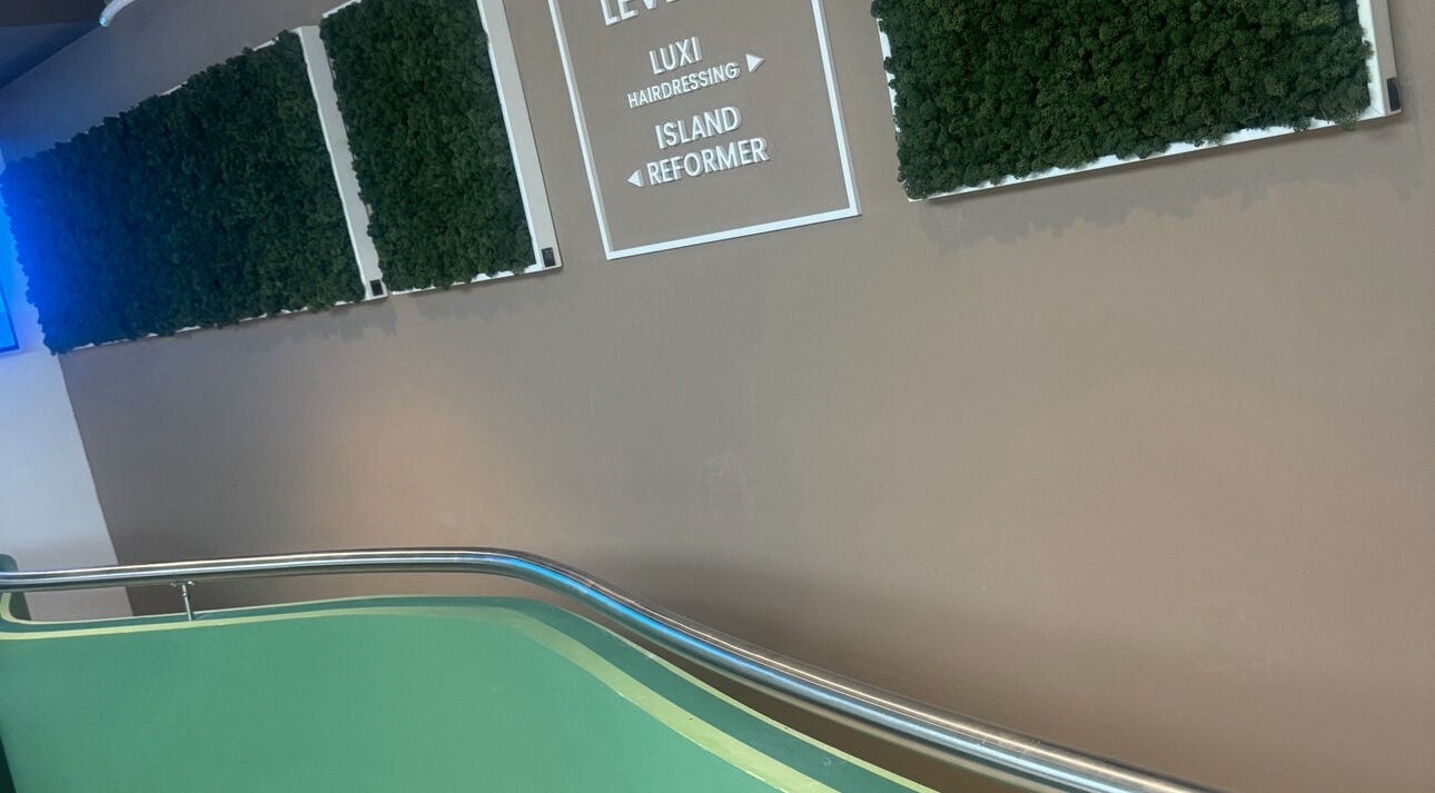 Entrance to Luxi Hairdressing in Tas-sliema, MT with green decor and clear signage.