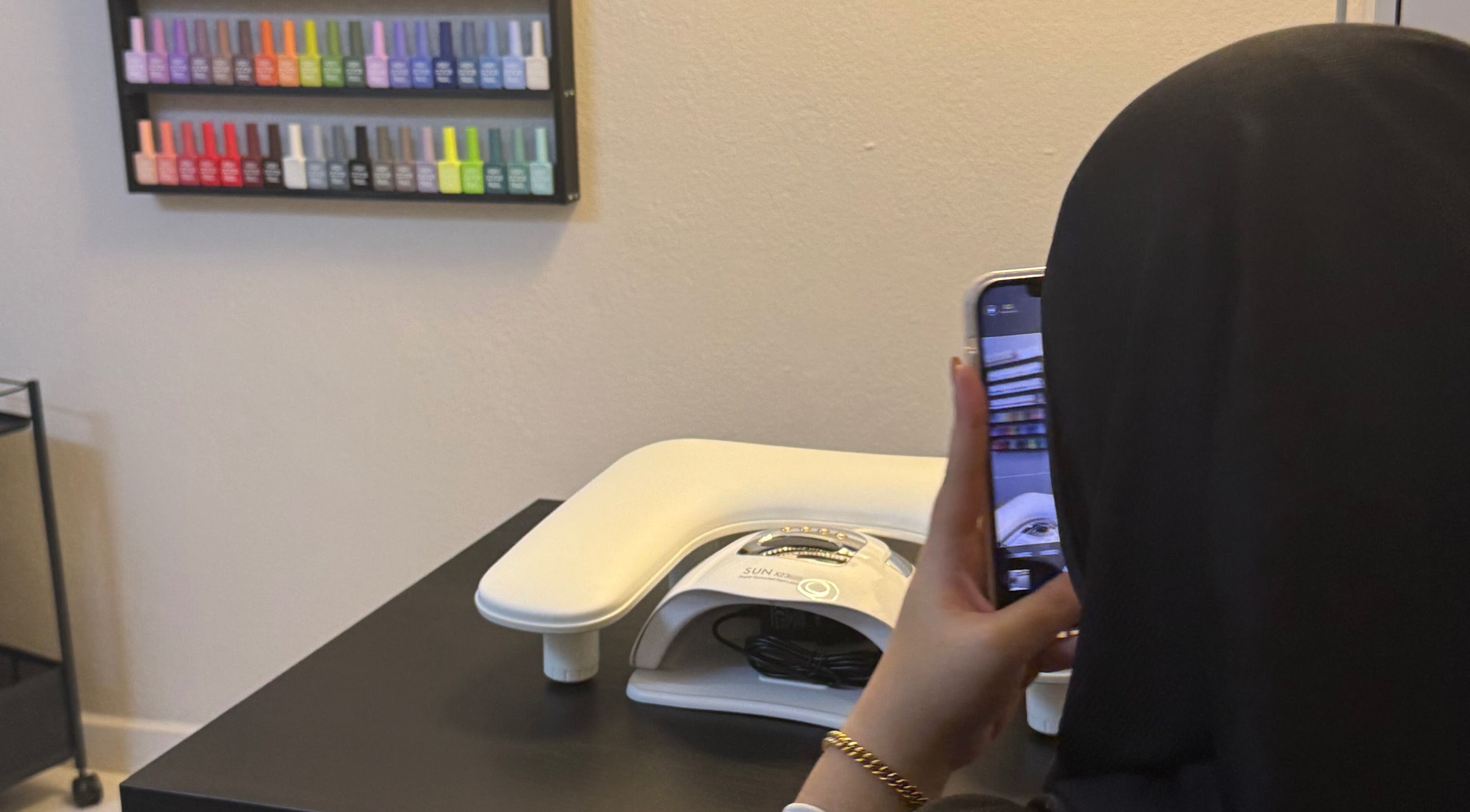 Person photographing nail polishes at HSQ BEAUTY, Balik Pulau, Pulau Pinang, MY. Vibrant colors displayed.