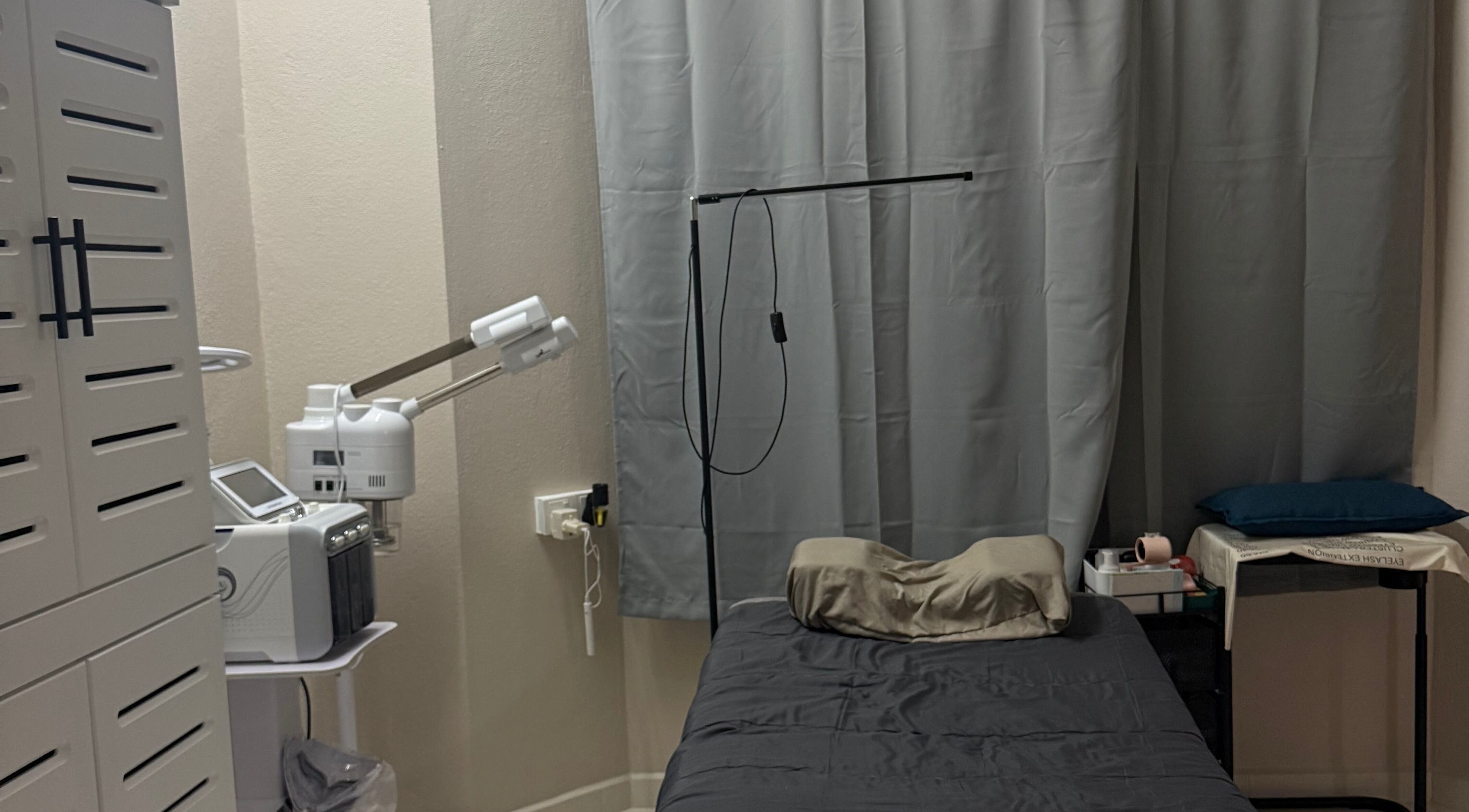 A serene treatment room at HSQ BEAUTY in Balik Pulau, Pulau Pinang, MY, featuring a comfortable bed and equipment.