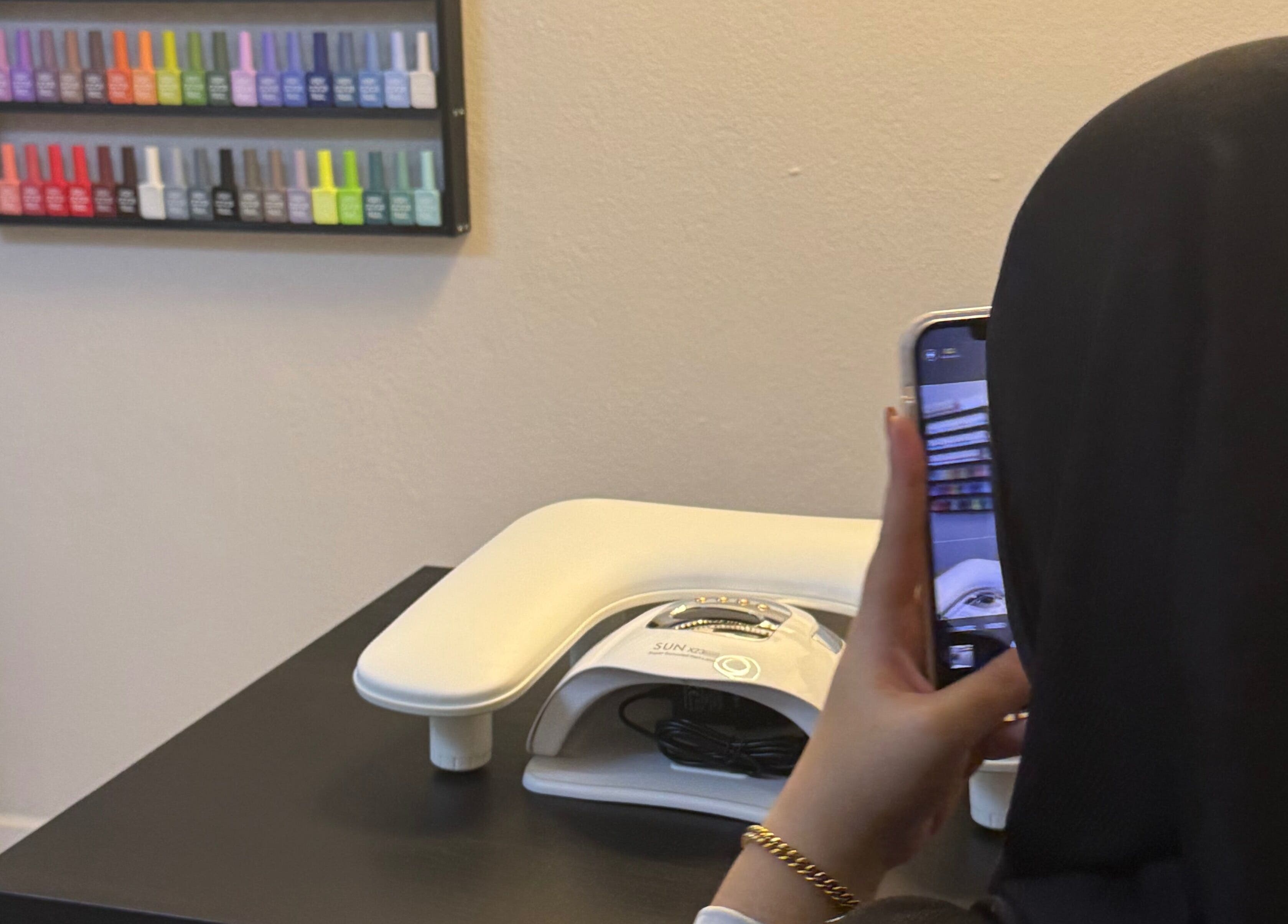 Person photographing nail polish display at HSQ BEAUTY, Balik Pulau, Pulau Pinang, MY.