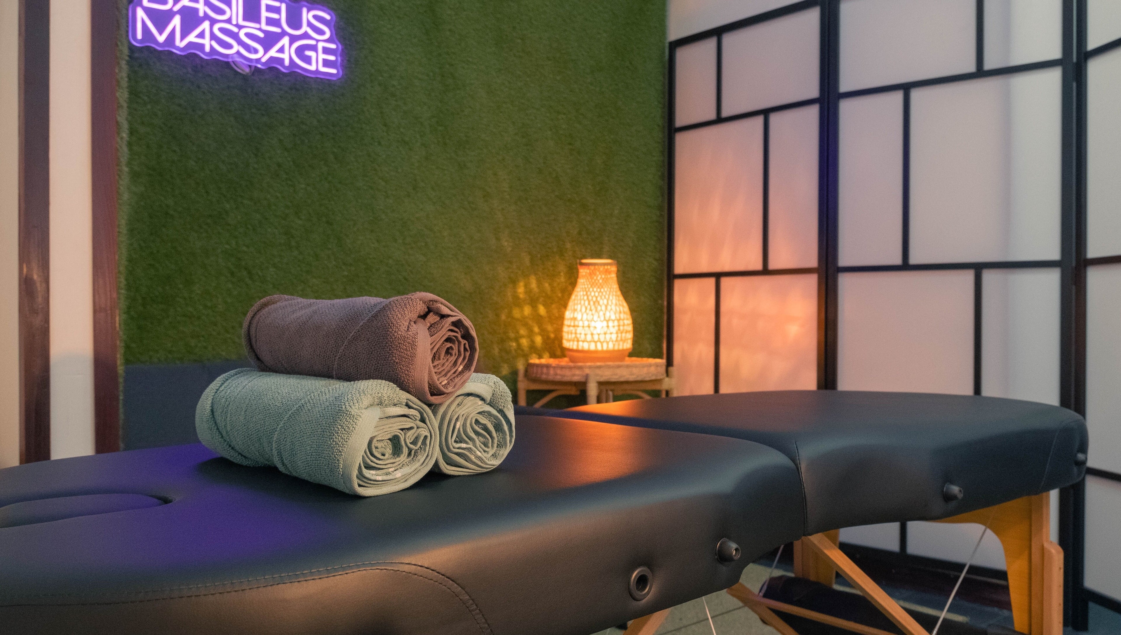 Masažni stol s ručnicima u Basileus Masaža, Beograd, RS, s ugodnim osvjetljenjem.
