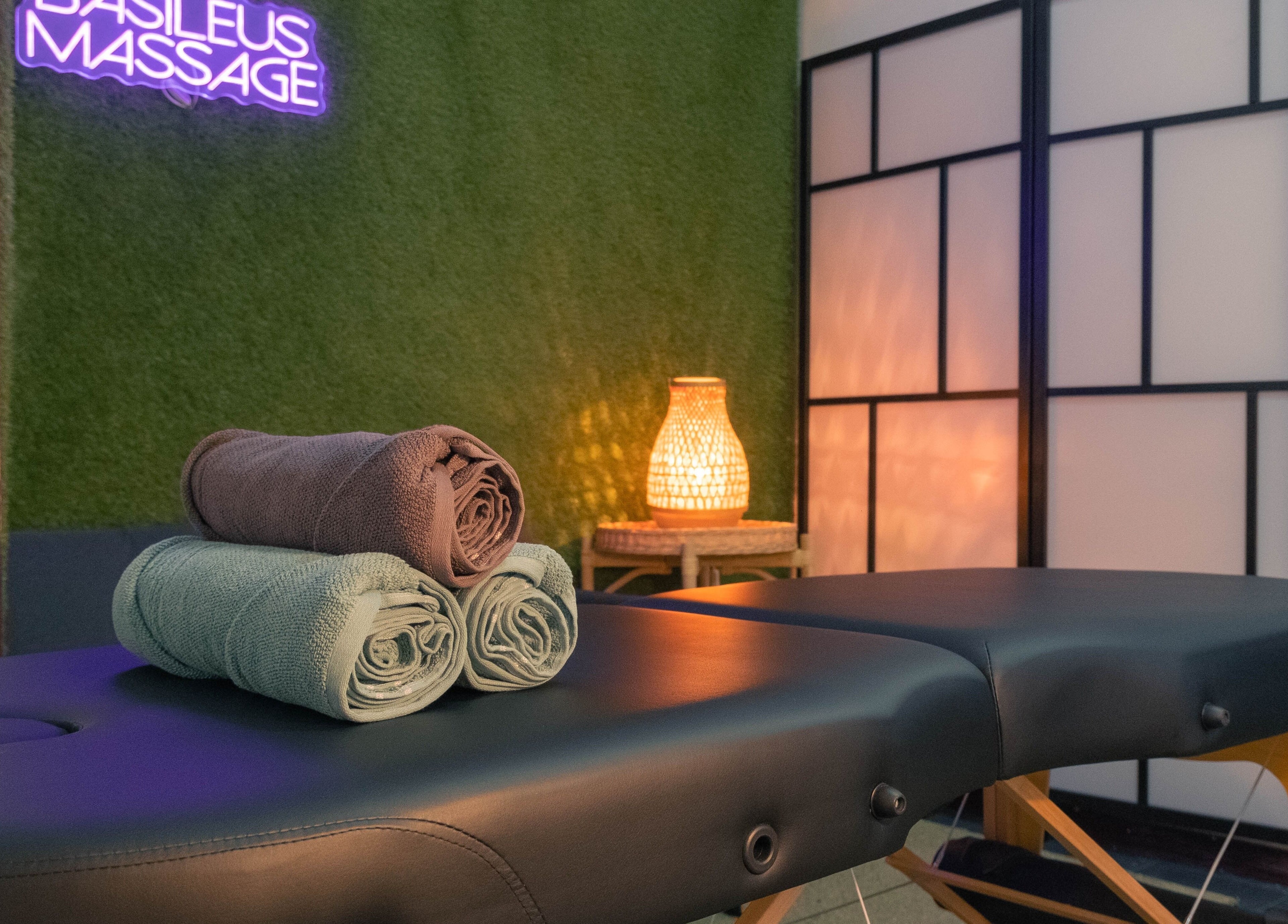 Masažni stol s ručnicima u Basileus Masaža, Beograd, RS, s ugodnim osvjetljenjem.