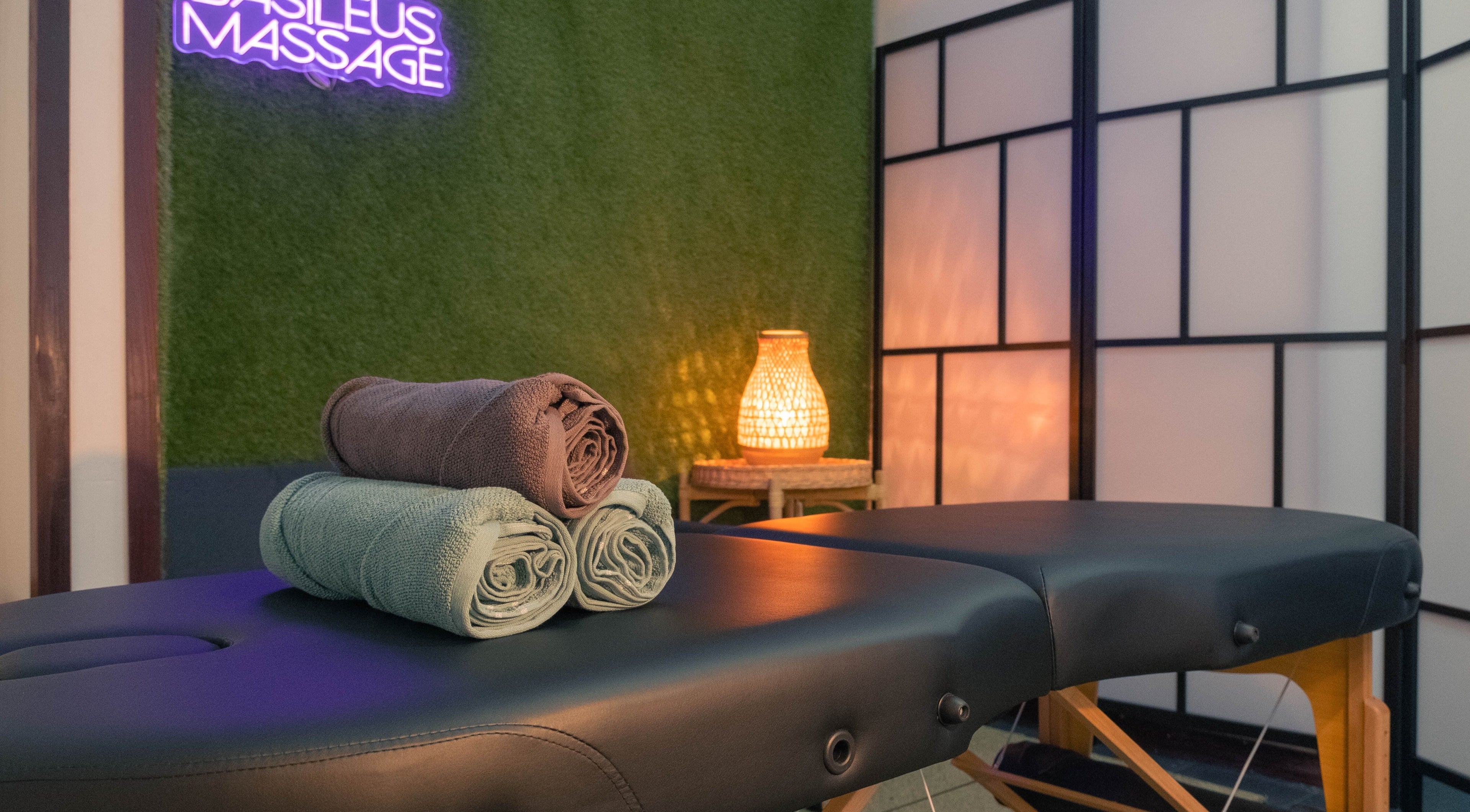 Masažni stol s ručnicima u Basileus Masaža, Beograd, RS, s ugodnim osvjetljenjem.