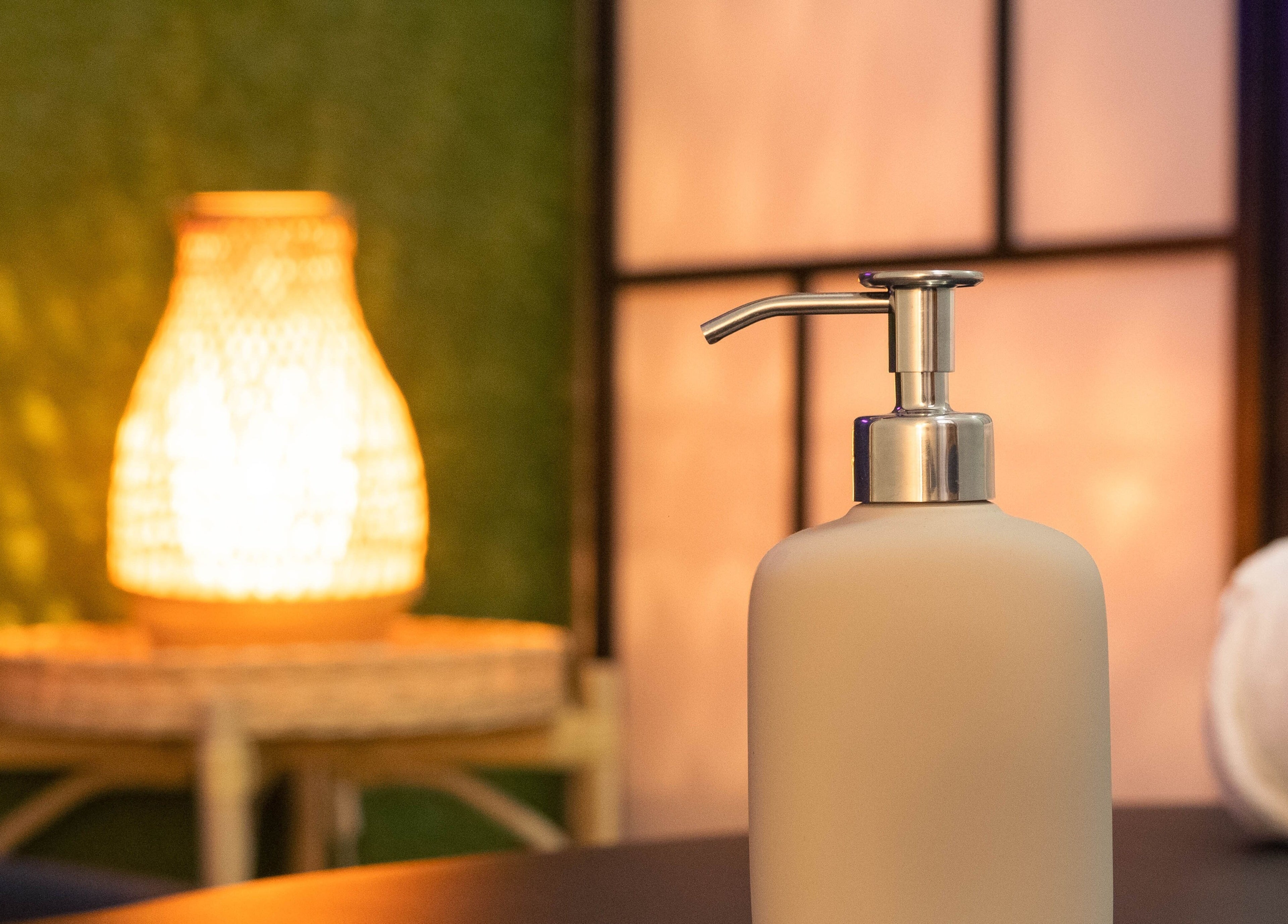 Umirujuća atmosfera u Basileus Masaža, Beograd, RS s dozatorom sapuna i ambijentalnim svjetlom.