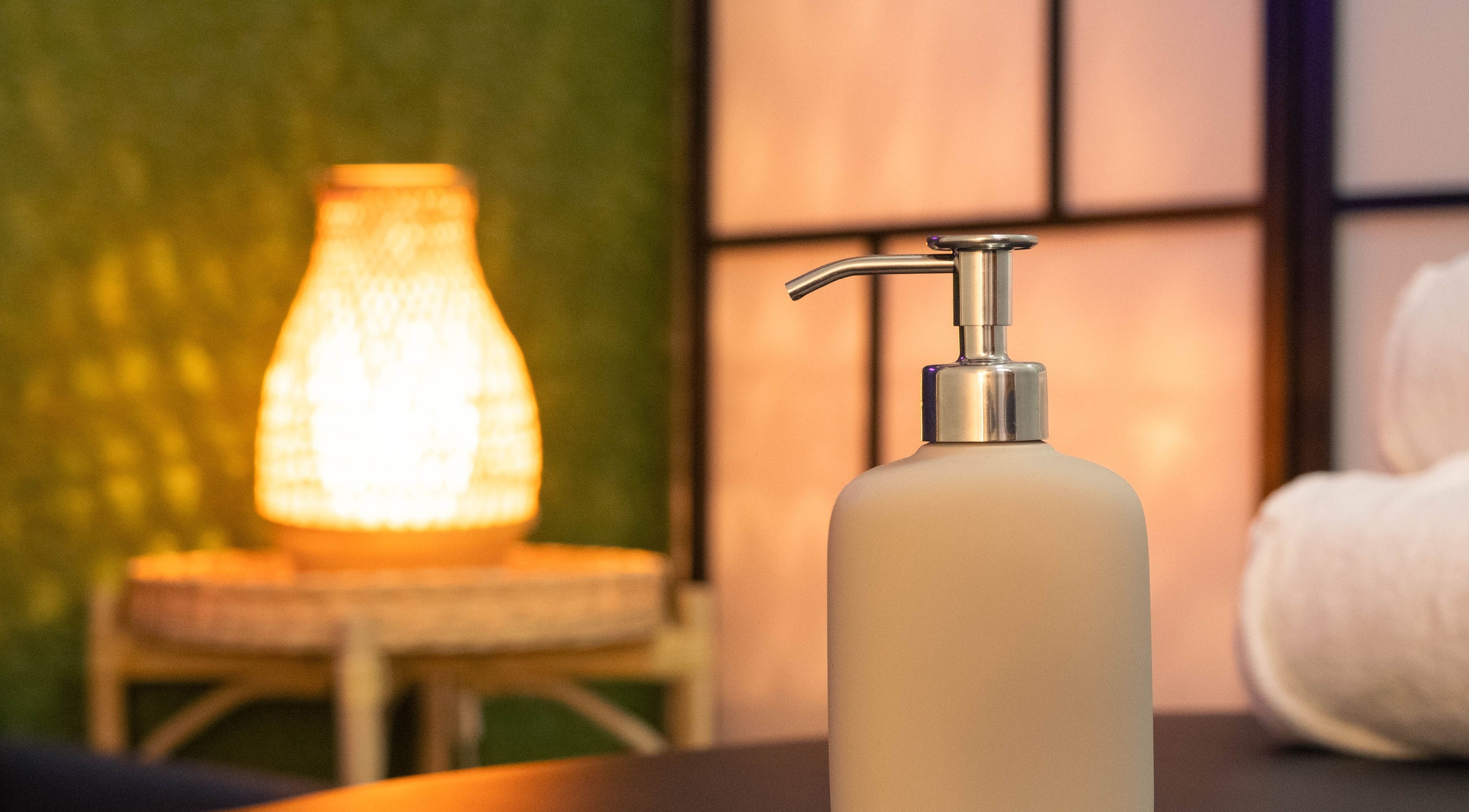 Umirujuća atmosfera u Basileus Masaža, Beograd, RS s dozatorom sapuna i ambijentalnim svjetlom.