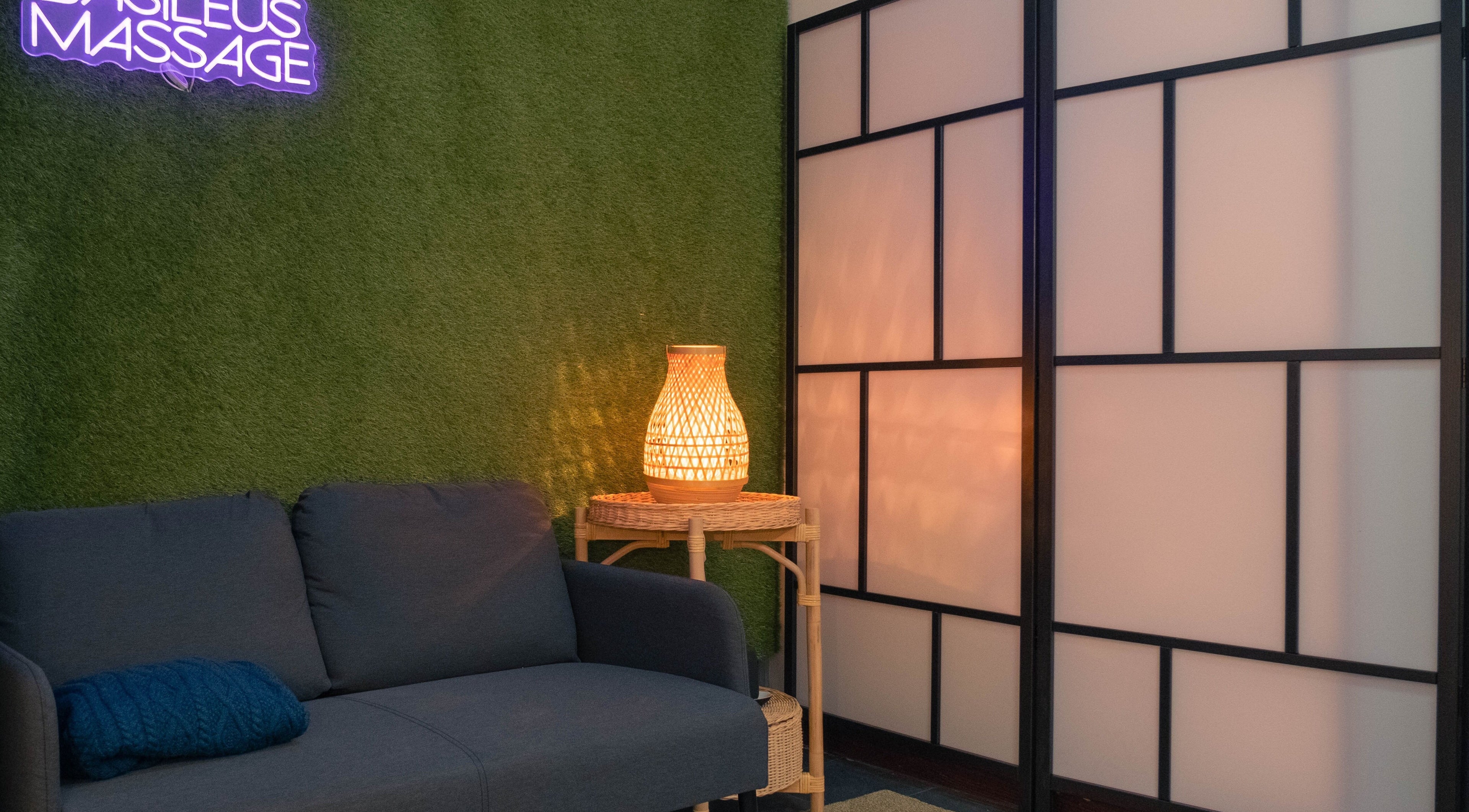 Elegantan interijer salona Basileus Masaža u Beogradu s udobnom sofom i ambijentalnom rasvjetom.