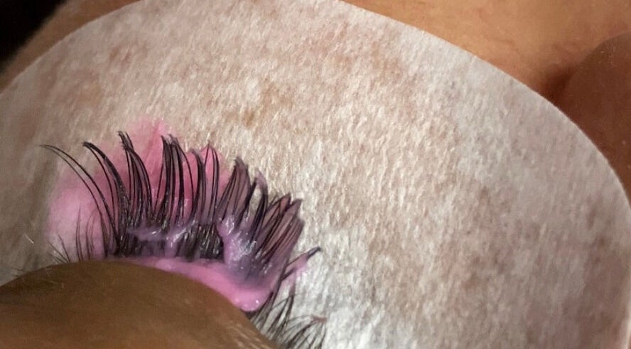 Close-up of a lash extension process at NĀSKIN, Cape Town, Western Cape, ZA with pink adhesive.