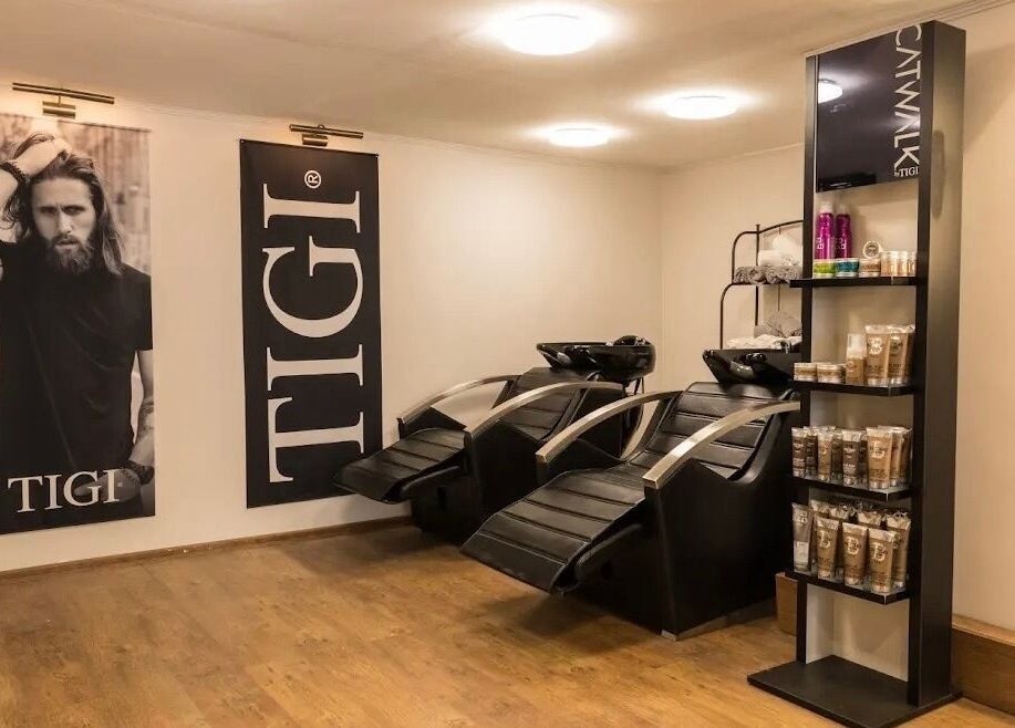 Sleek shampoo area at Cleancut, Budapest, Magyar featuring modern chairs and product display.