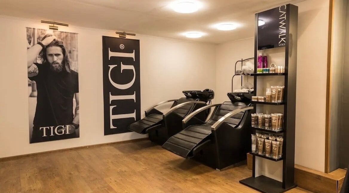 Sleek shampoo area at Cleancut, Budapest, Magyar featuring modern chairs and product display.