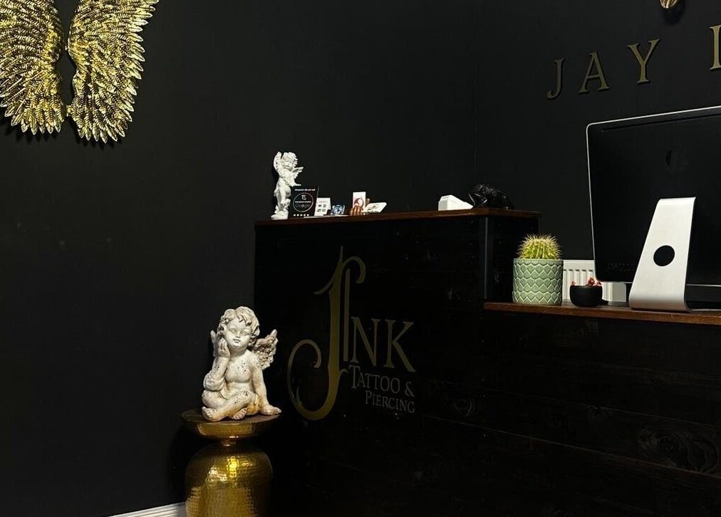 Eleganter Empfangsbereich bei Schahab Tattoo, Hamburg, Hamburg, DE, mit goldenen Engelsflügeln und Skulptur.