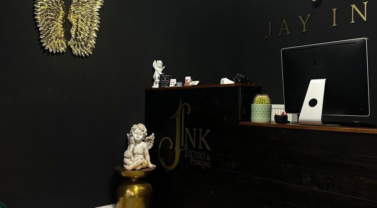 Eleganter Empfangsbereich bei Schahab Tattoo, Hamburg, Hamburg, DE, mit goldenen Engelsflügeln und Skulptur.