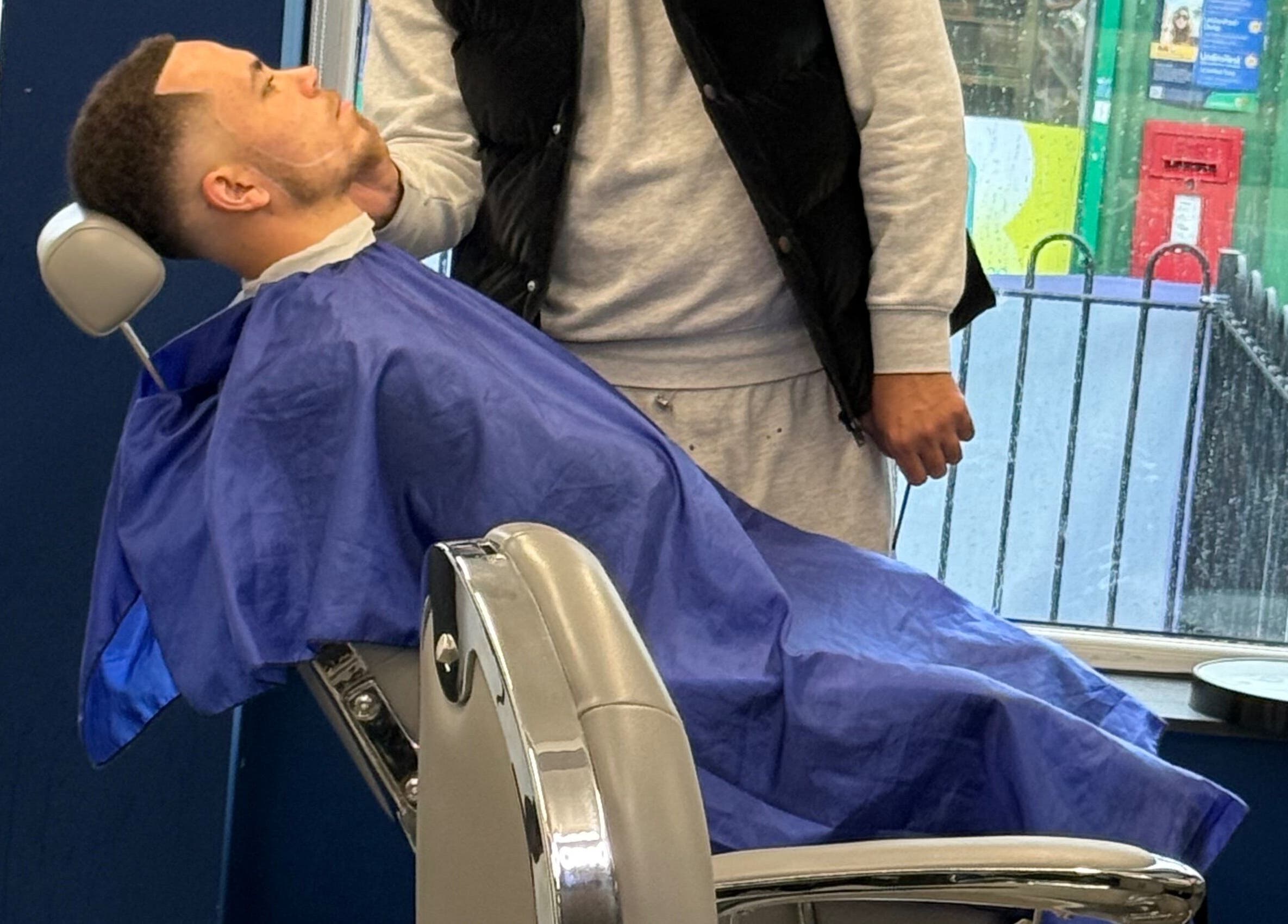 A client receiving a precise haircut at Marlos Barber High Wycombe, England, GB.