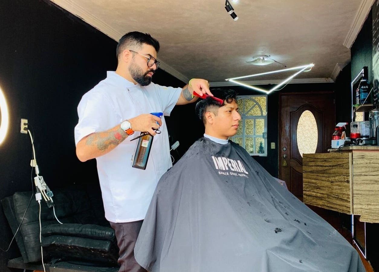 Barbero en Barberia la doble s, Ciudad De México, MX, cortando el cabello a un cliente en un ambiente moderno.