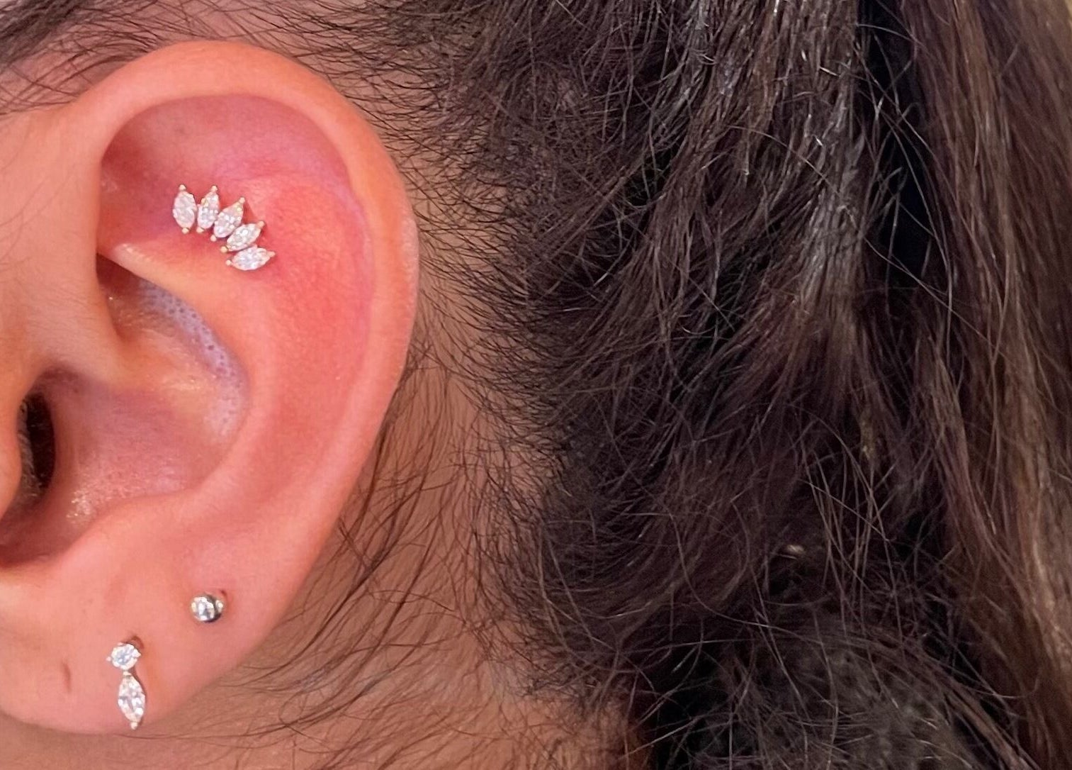 Stylish ear piercings with jewelry at Karismatic Studio, Derby, England, GB.