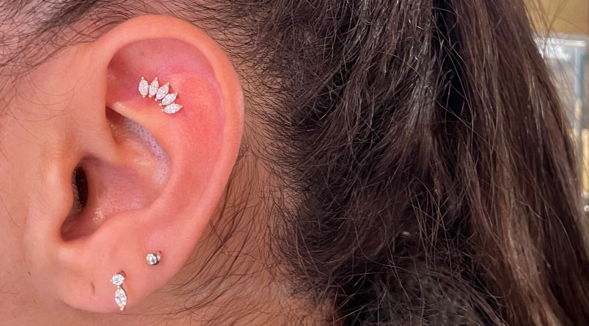 Stylish ear piercings with jewelry at Karismatic Studio, Derby, England, GB.