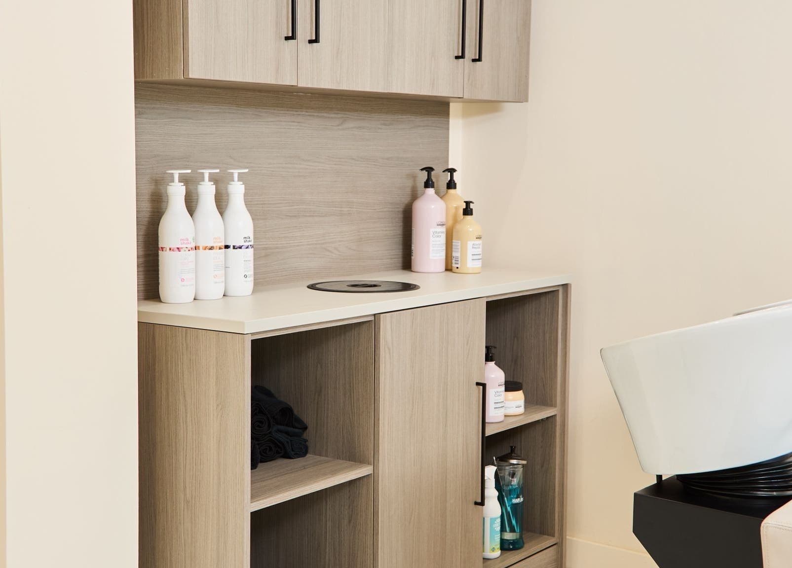Modern salon shampoo station at S.Rose By Linda, Ramsbottom, England, GB, with stylish wooden cabinets.