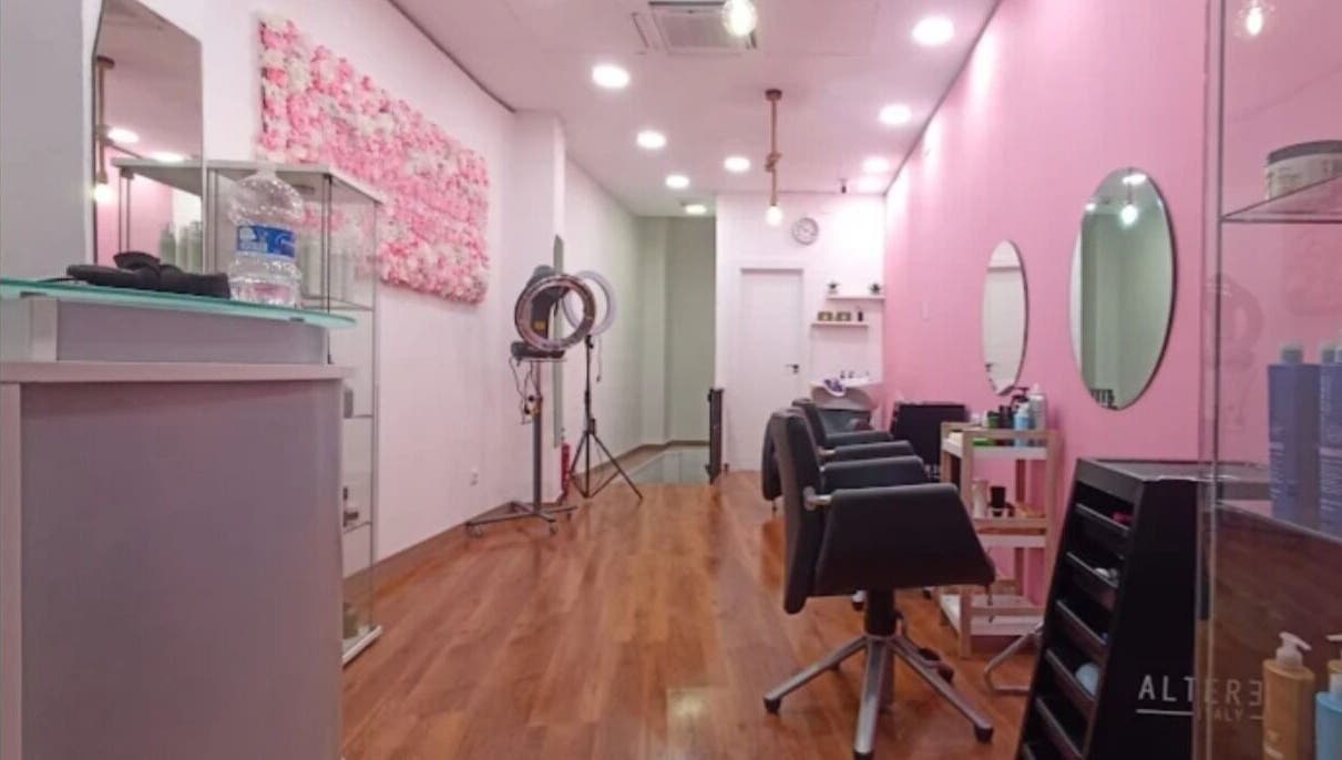 Interior moderno y elegante de Lola Bloom Nails en Cartagena, Región De Murcia, ES. Sillas de peluquería, pared rosa.