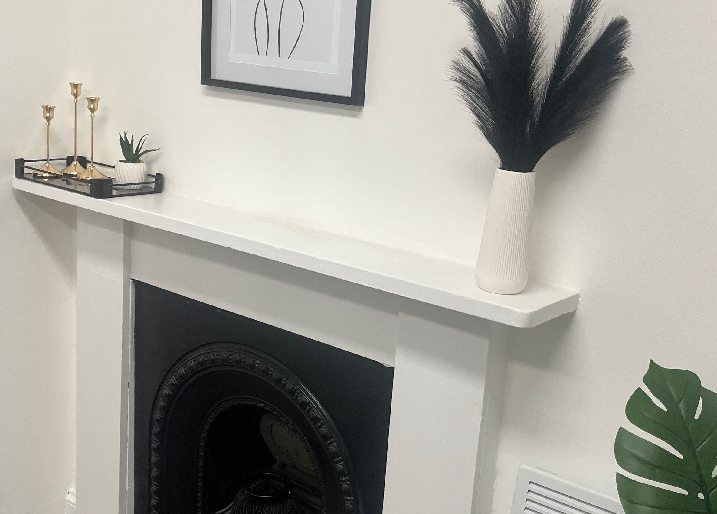 Elegant fireplace decor at Wylde Wax Studio, Glasgow, Scotland, GB featuring minimalist black and white accents.