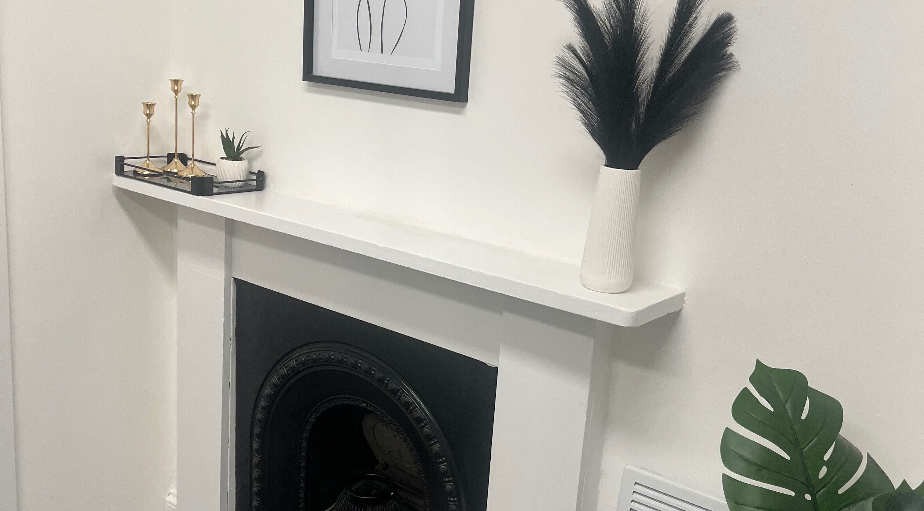 Elegant fireplace decor at Wylde Wax Studio, Glasgow, Scotland, GB featuring minimalist black and white accents.