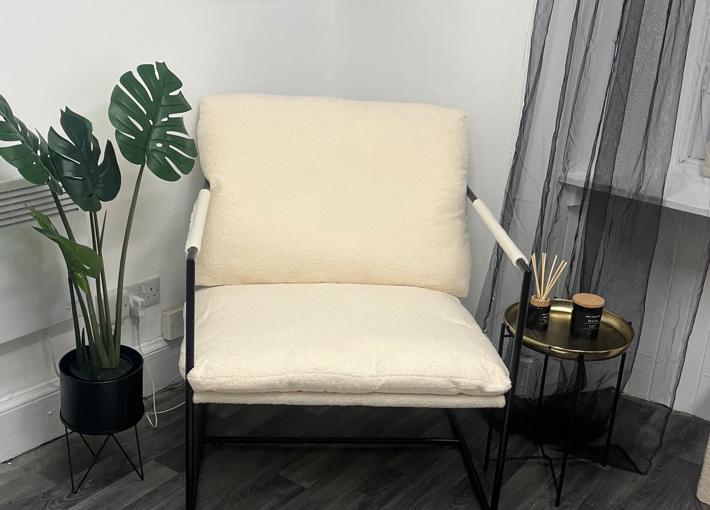 Relaxing cozy corner at Wylde Wax Studio, Glasgow, Scotland, GB with a plush chair and leafy plant.