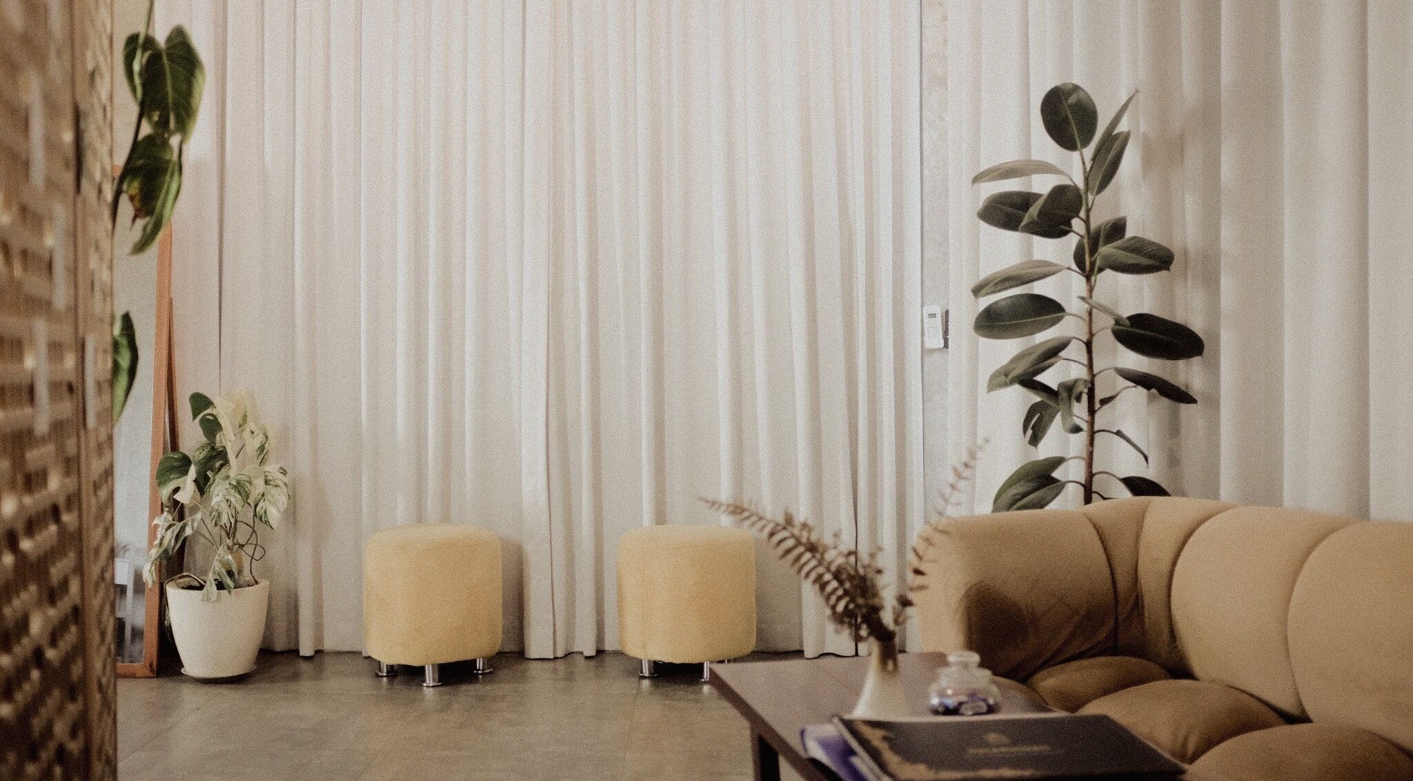 Modern lounge at Galerimikro Tattoo Studio, Bali, Bali, ID with plants, seating, and draped curtains.