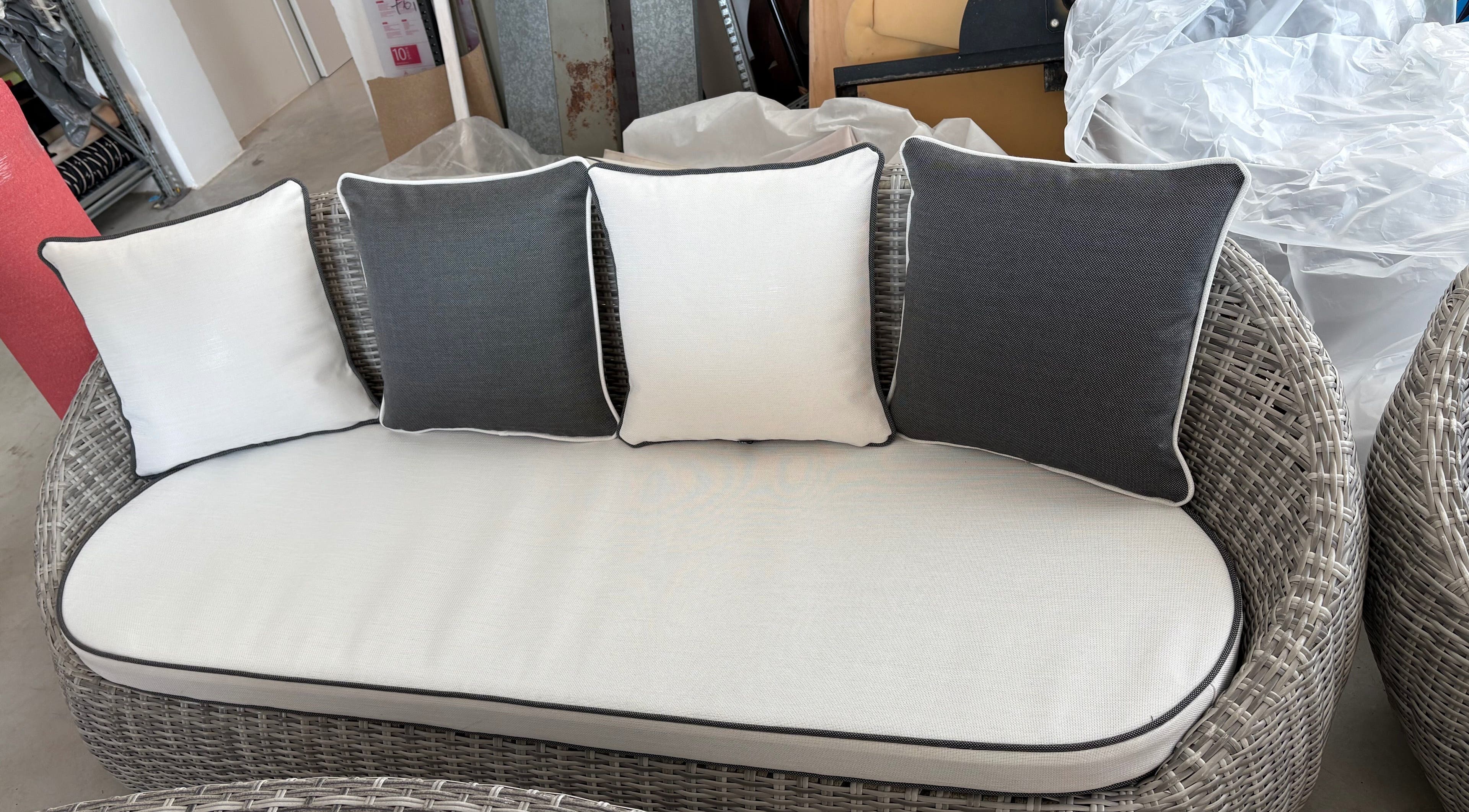 Divano intrecciato con cuscini bianchi e grigi a Rossi, Faenza, Emilia-romagna, IT.