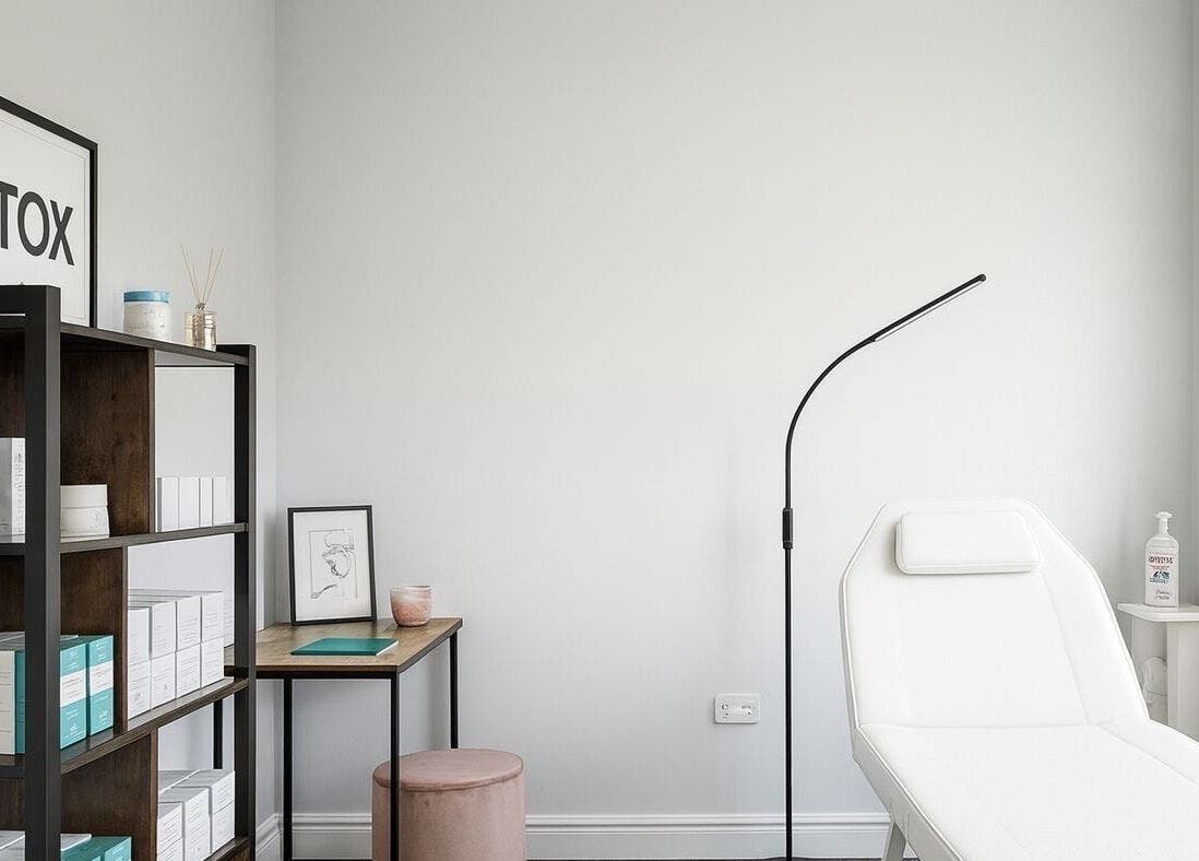 Modern treatment room at NovaSkin, County Kilkenny, IE featuring a sleek white bed and organized shelves.