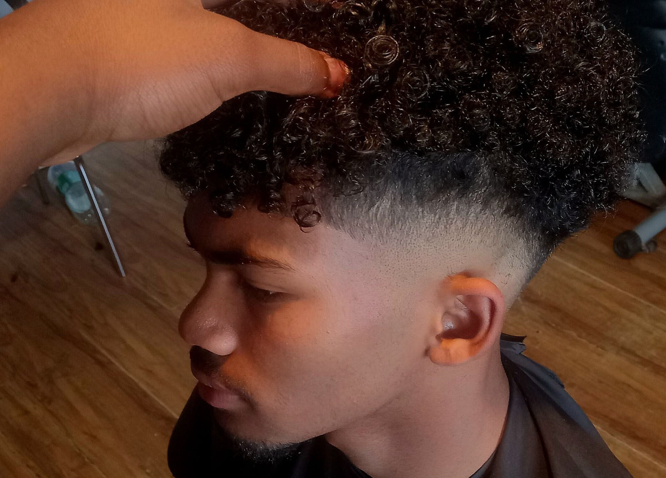 Expert barber styling curly hair at Seth's Parlor, Cape Town, Western Cape, ZA.