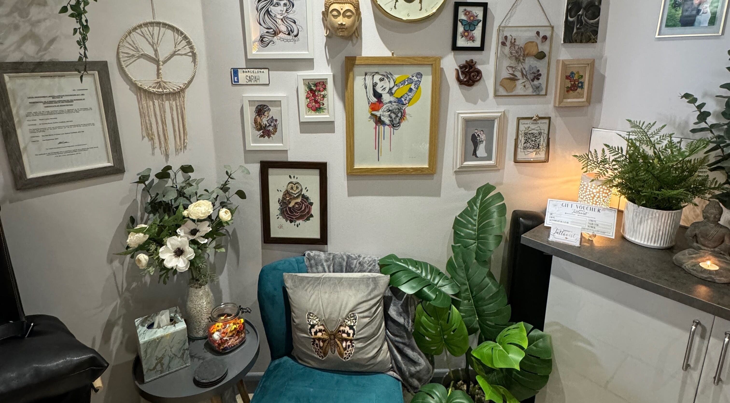 Sarah K Tattooist's artistic wall display in Birmingham, England, GB enhances the cozy wellness atmosphere.