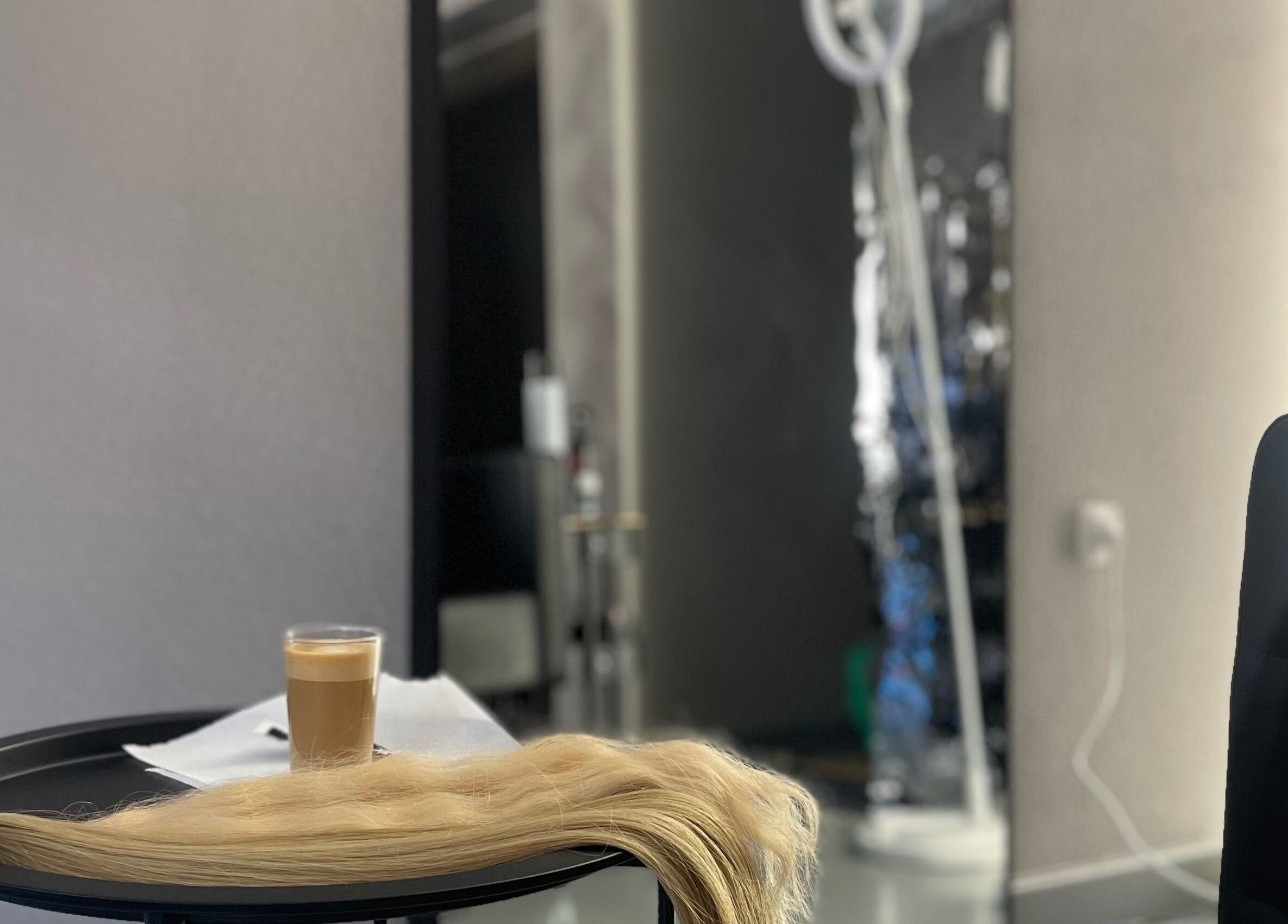 Mesa con café y extensiones de cabello en Art Capsula, Pinto, Comunidad De Madrid, ES.