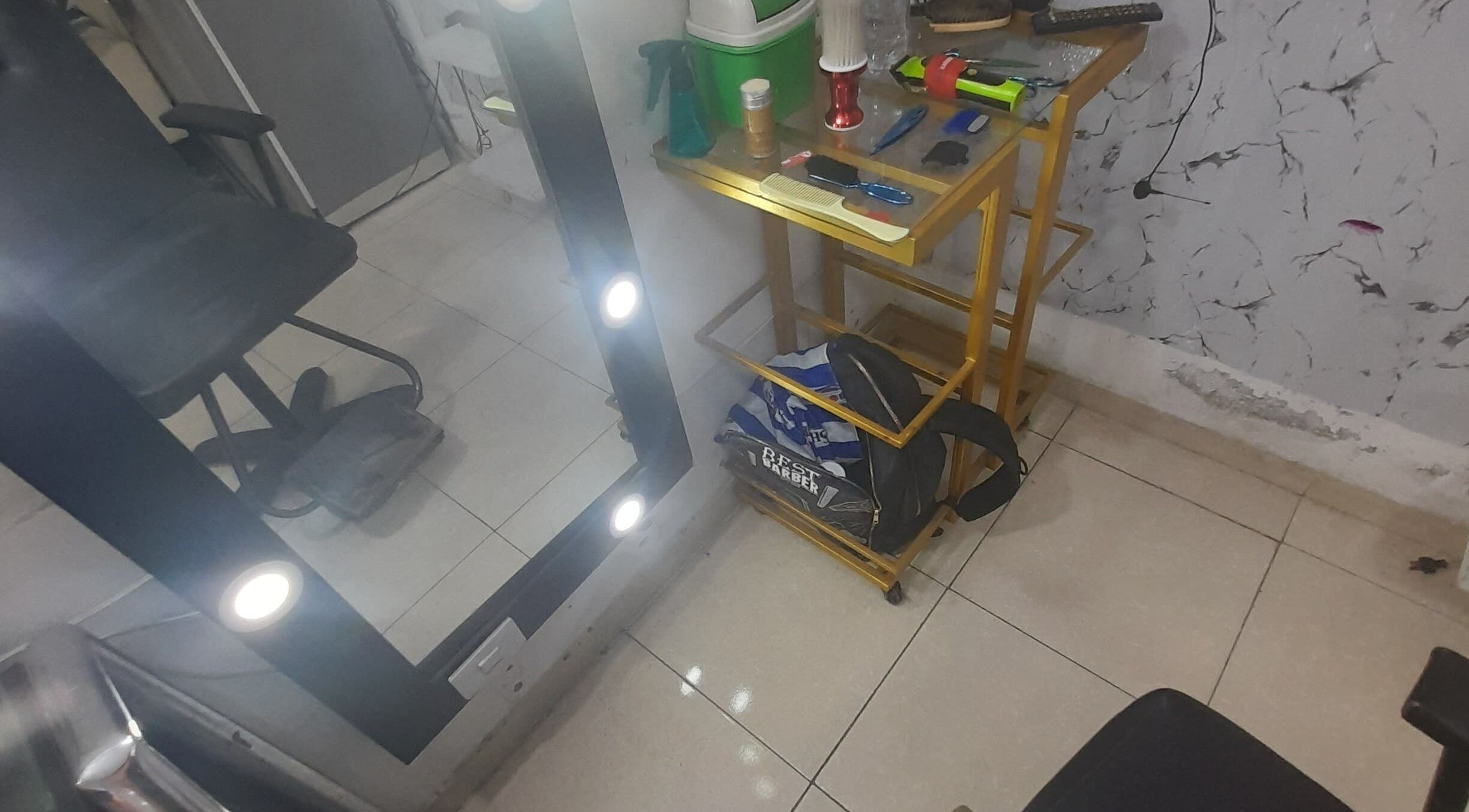 Estación de trabajo en La Barber Wawy, Valle Del Cauca, CO, con asiento y espejo iluminado.