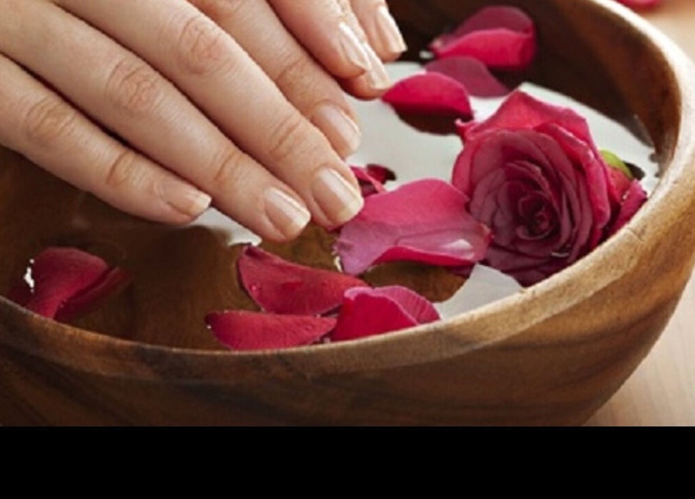 Hand soaking in rose petal bowl at Shellac Nail & Spa, Oklahoma City, Oklahoma, US, enhancing relaxation.